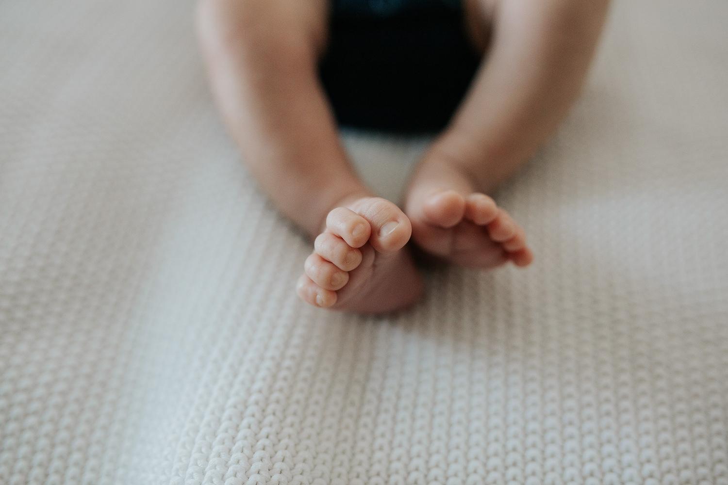 close up of 2 week old baby boy's toes lying on white knit blanket - GTA In-Home Photography