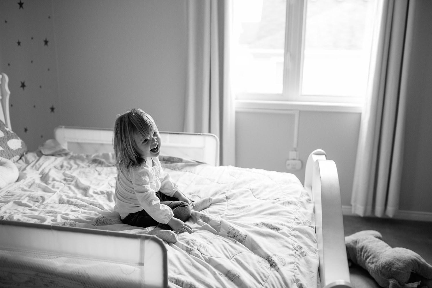 Markham In-Home Photography -little girl playing on her bed, classic black and white toddler image