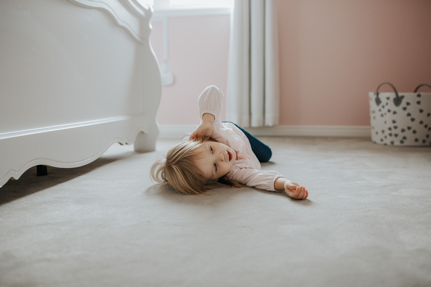 2 year old toddler girl lying on the floor of her pink coloured bedroom - Markham In-Home Photos
