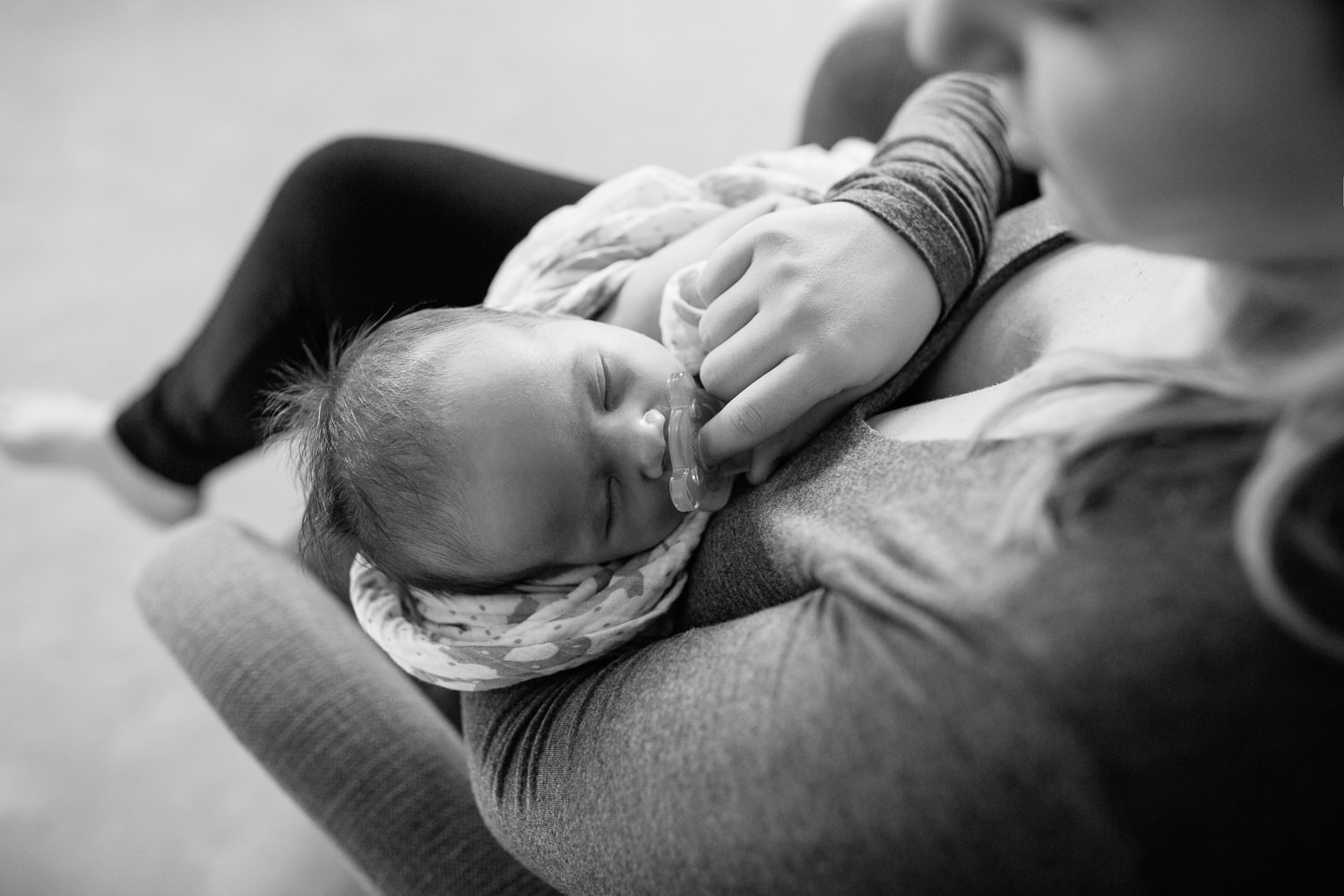 Markham Lifestyle Photography - an above shot of a mother soothing her 2 week old baby boy with a soother. 