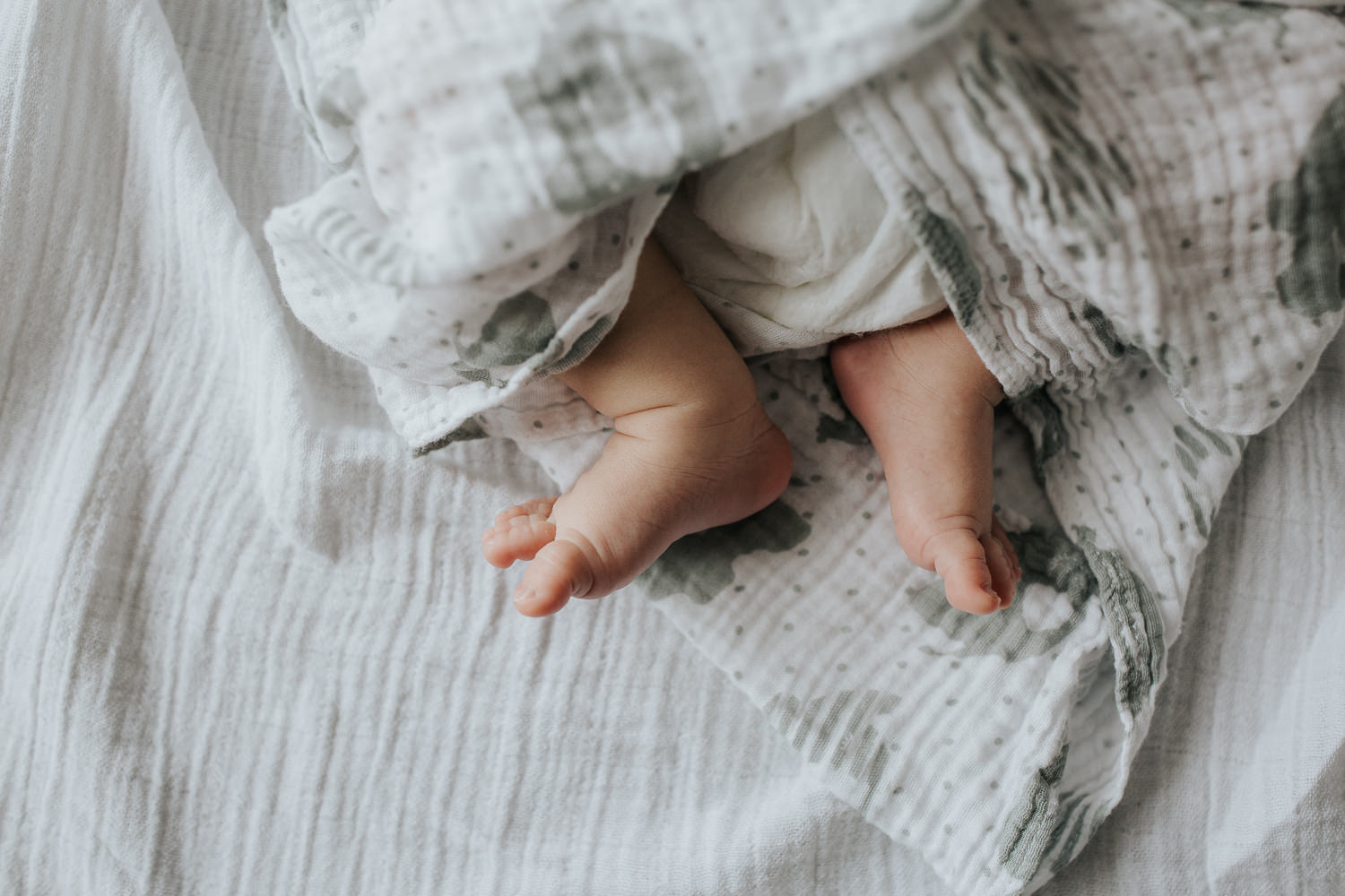 Barrie In-Home Photos - close up photo of 2 week old baby boy toes peeking out of swaddle