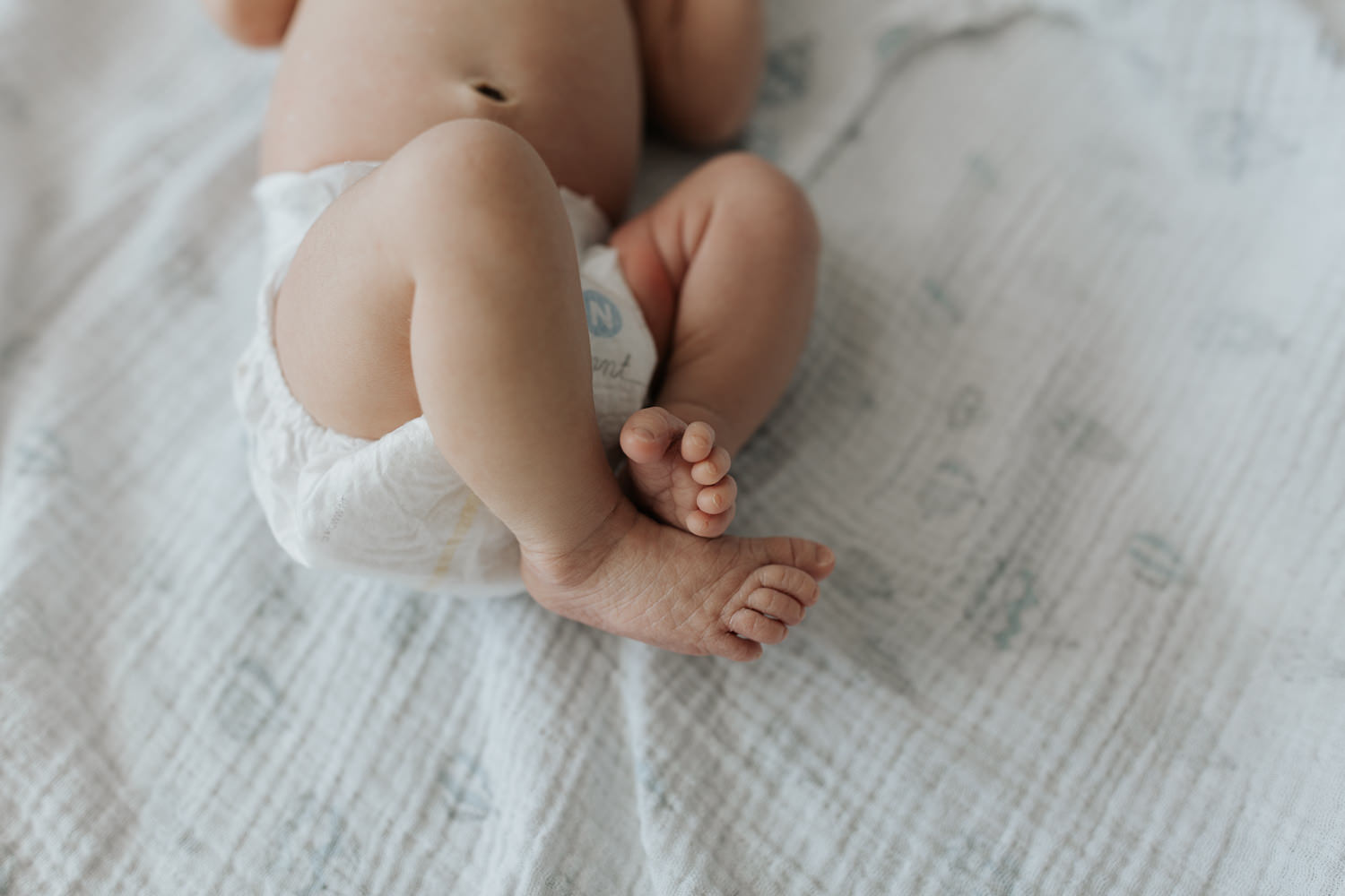2 week old baby boy in diaper lying on swaddle, close up of feet - Markham Lifestyle Photography