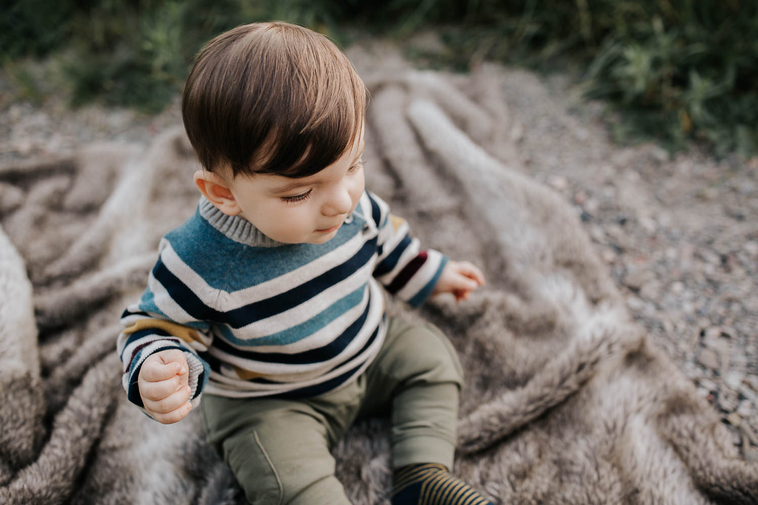 1 year old boy with brown hair and eyes wearing striped sweater sitting on blanket in outdoor path down - Markham Golden Hour Photos