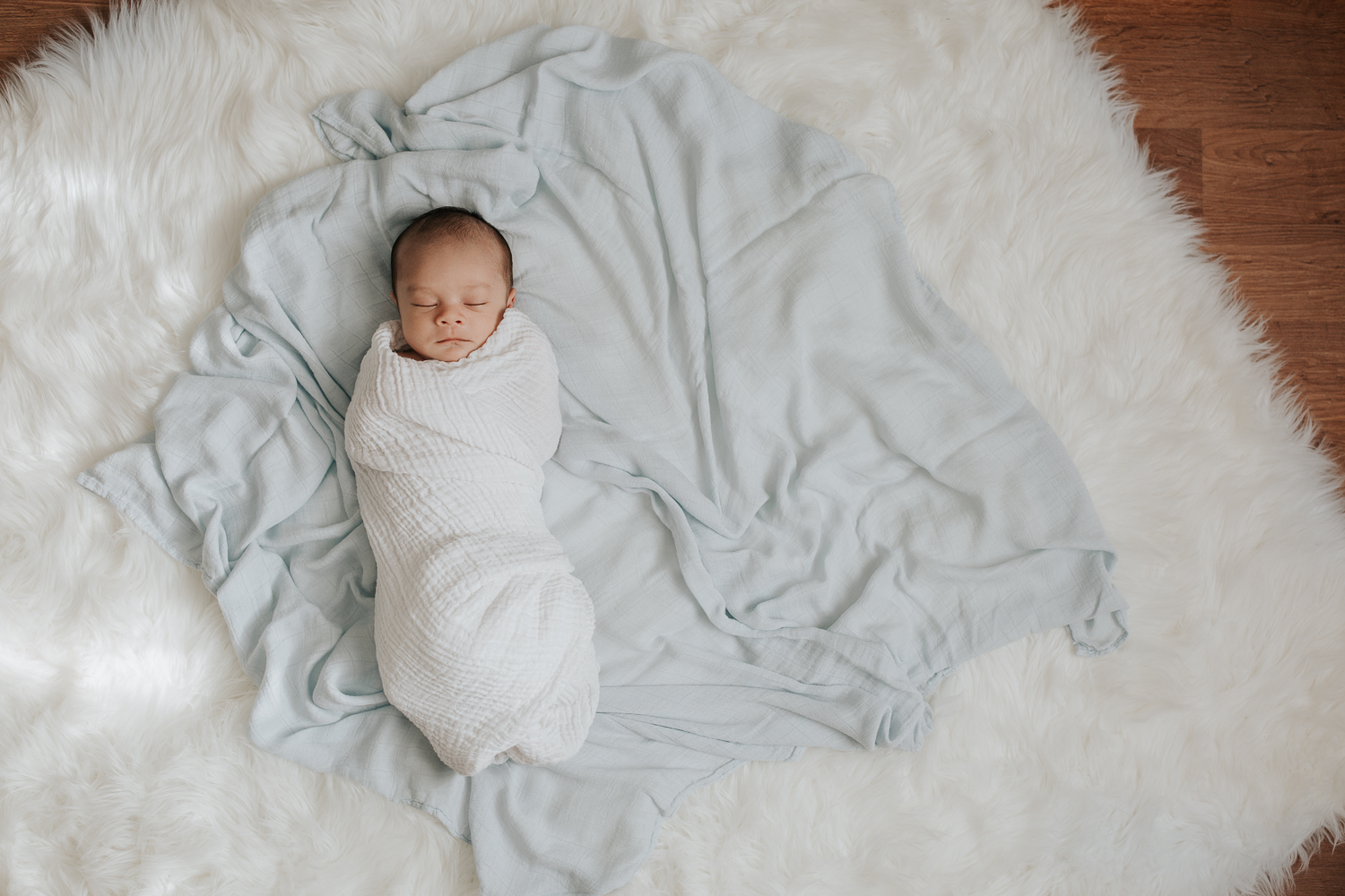 3 week old baby boy with dark hair sleeping wrapped in white swaddle, portrait - Barrie In-Home Photos