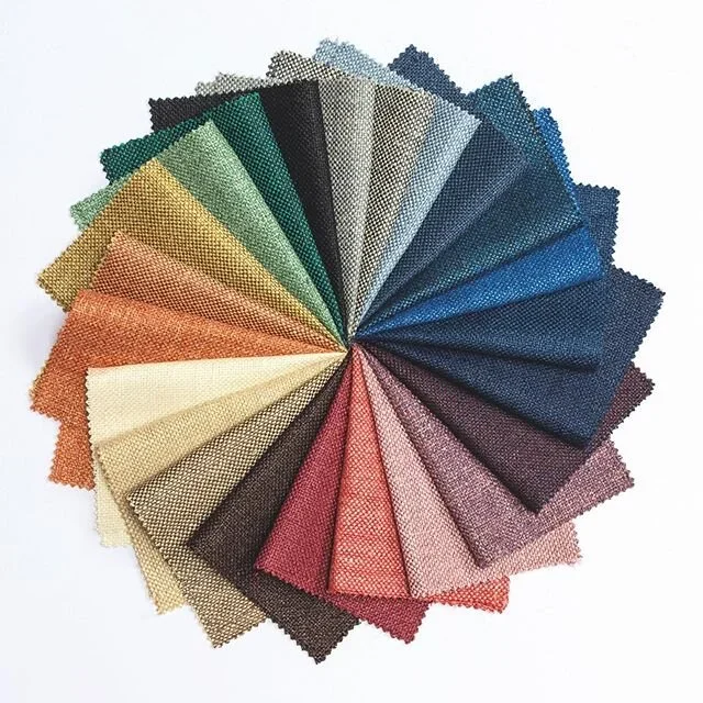 Waaier van meer dan twintig stofstalen voor bestuurspakken in kleuren van donkerblauw en grijs tot petrol, bordeaux, groen en goud