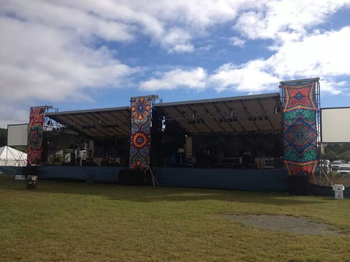 Here is our festival stage. Each side is 33' wide x 24' deep. Monitor world is 10' x 10' in the center. We typically fly 8 line array per tower. {The banners are not included}