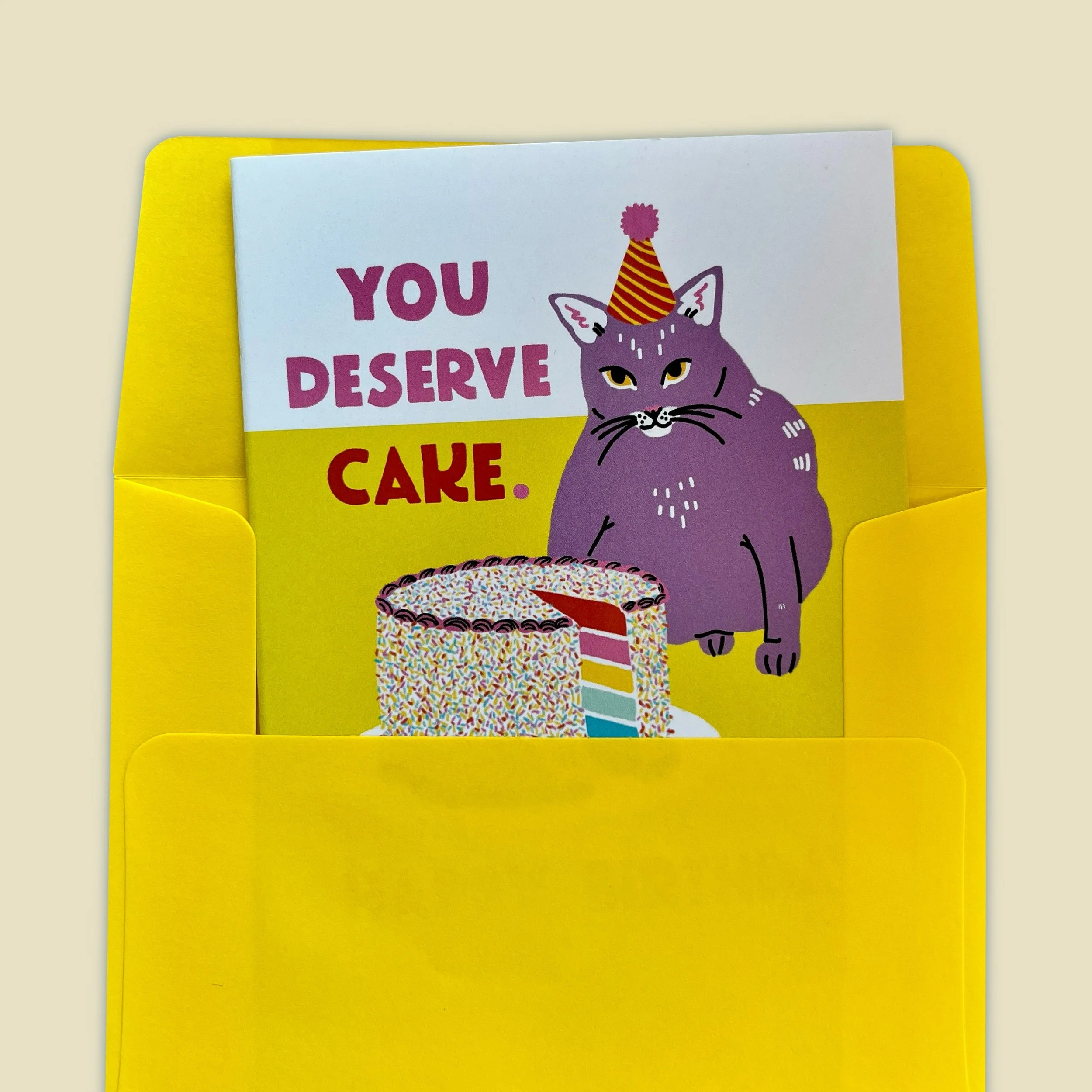 a card of a cat that says "you deserve cake"