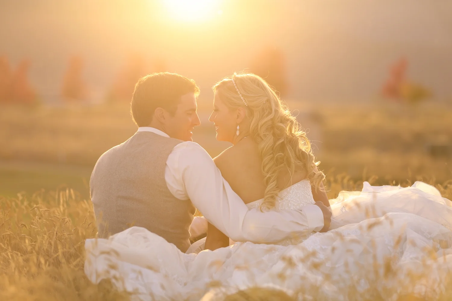 Montana Bride and groom sitting in a field at sunset