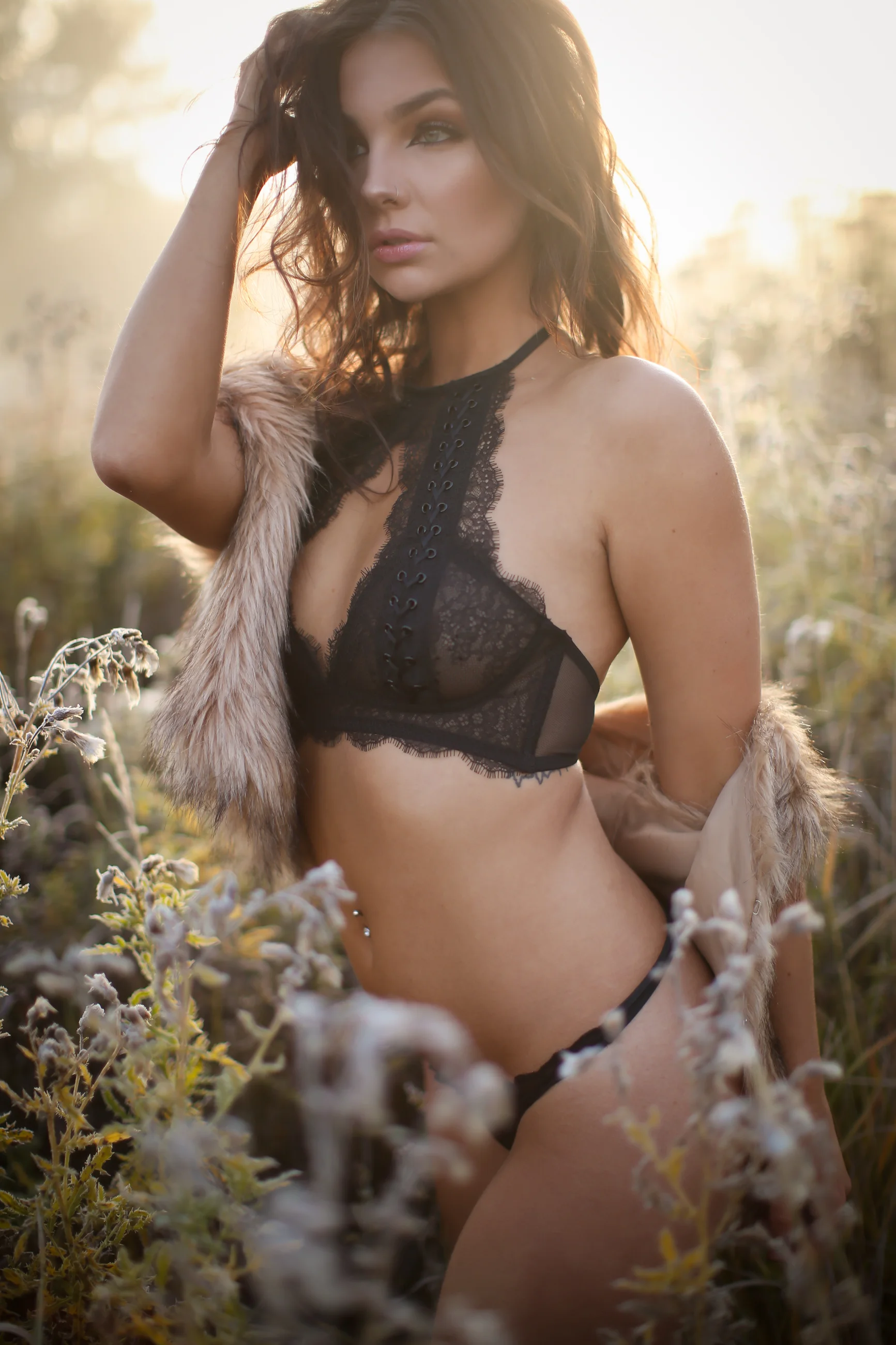 Boudoir portrait of woman in cute bralette in a field outdoors
