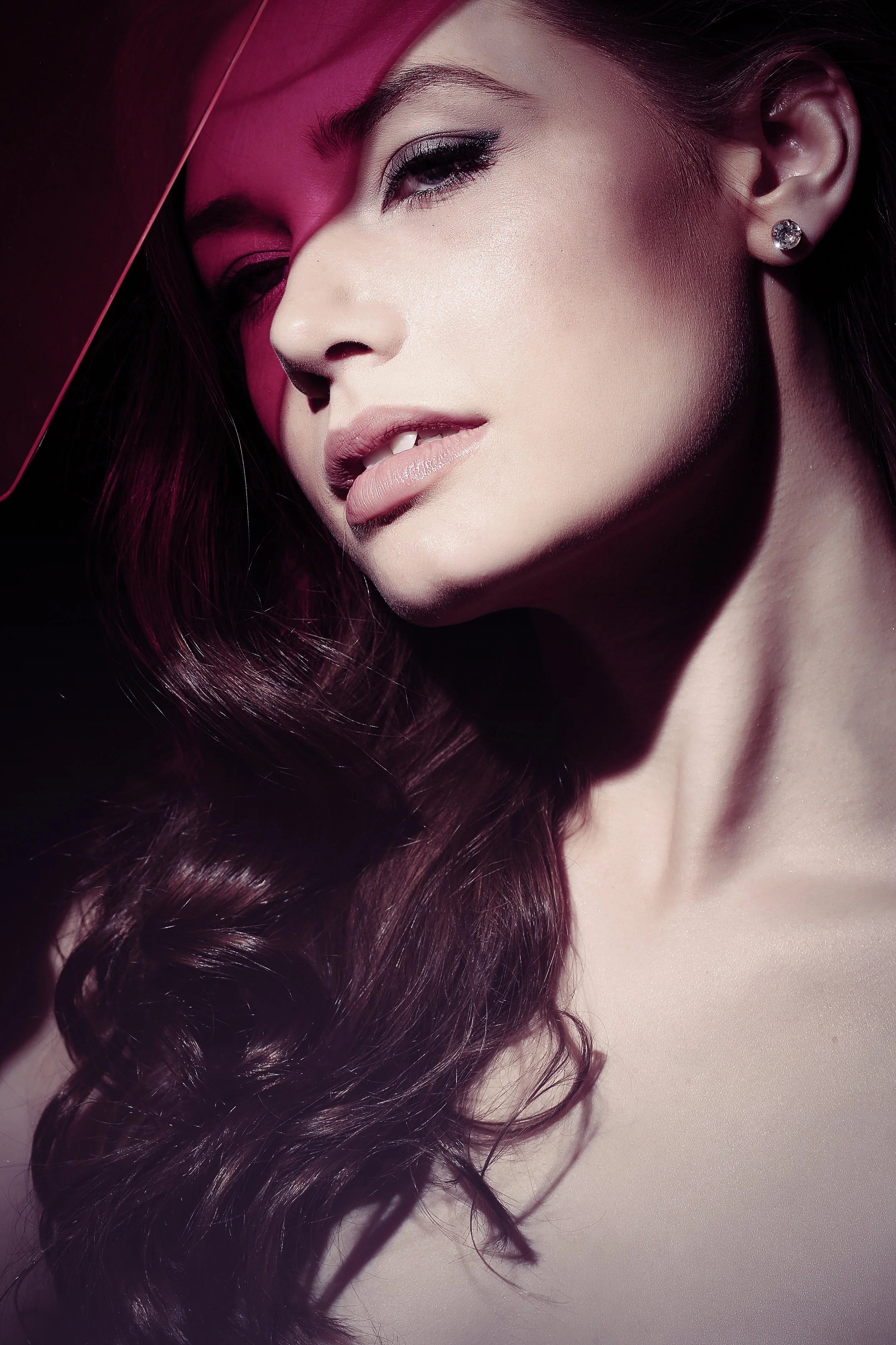 Fashion model in editorial photograph in studio with colored gels highlighting her face