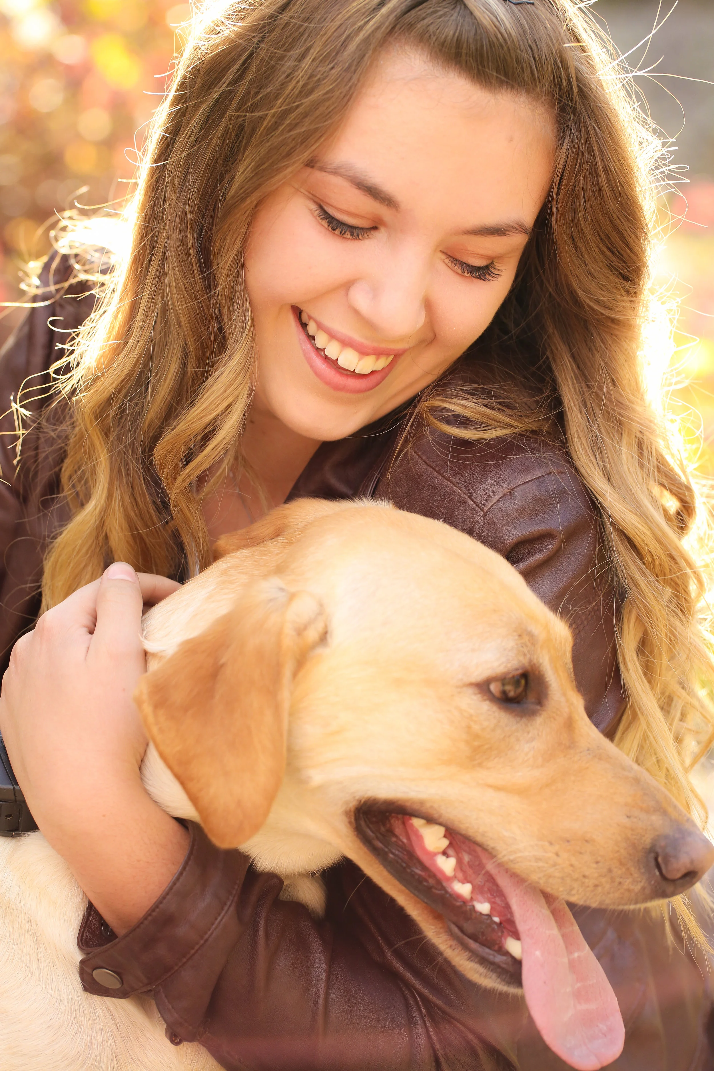 Senior portrait of Montana high school senior in a leather jacket hugging her dog