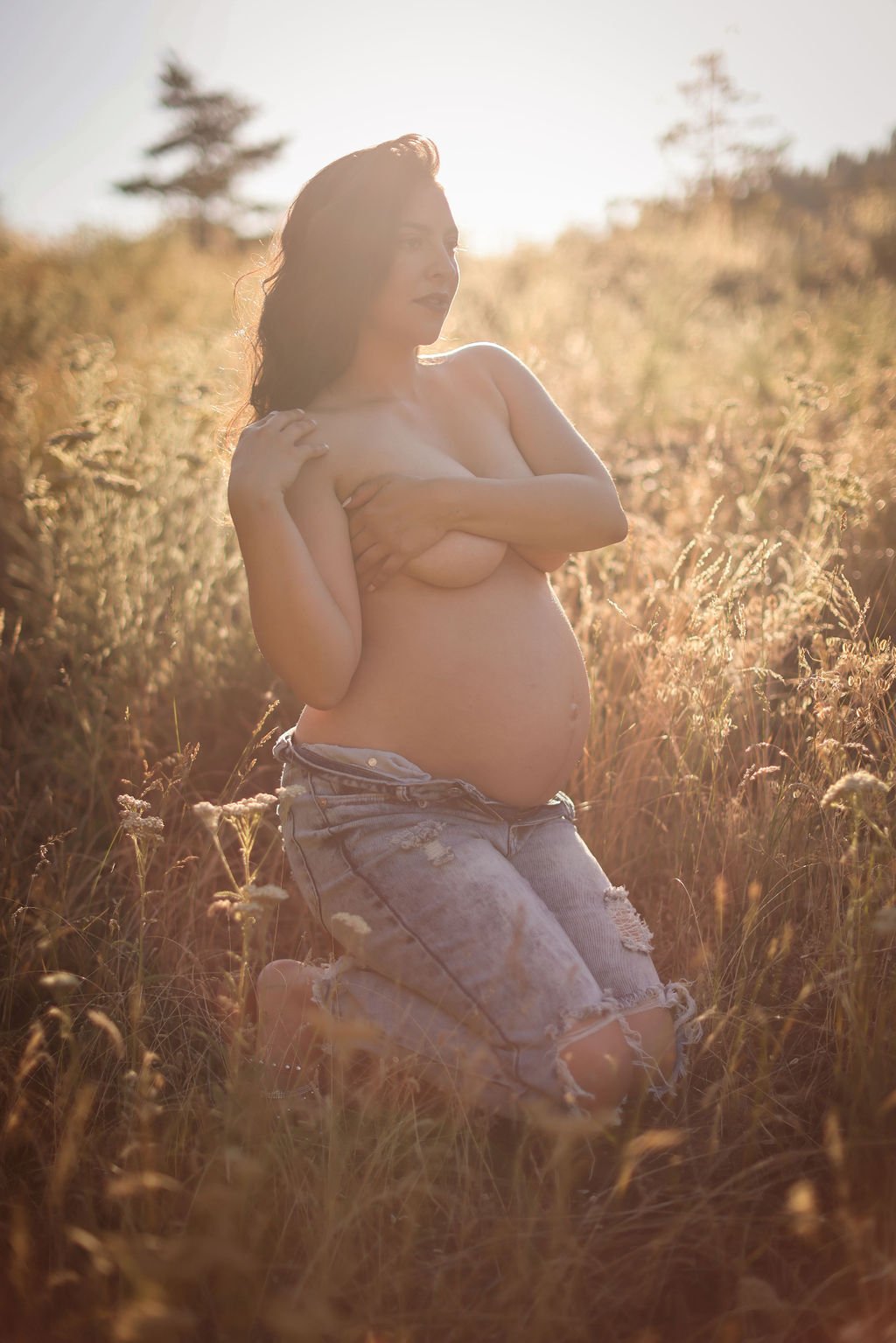 Pregnant woman topless in jeans at golden hour.jpg