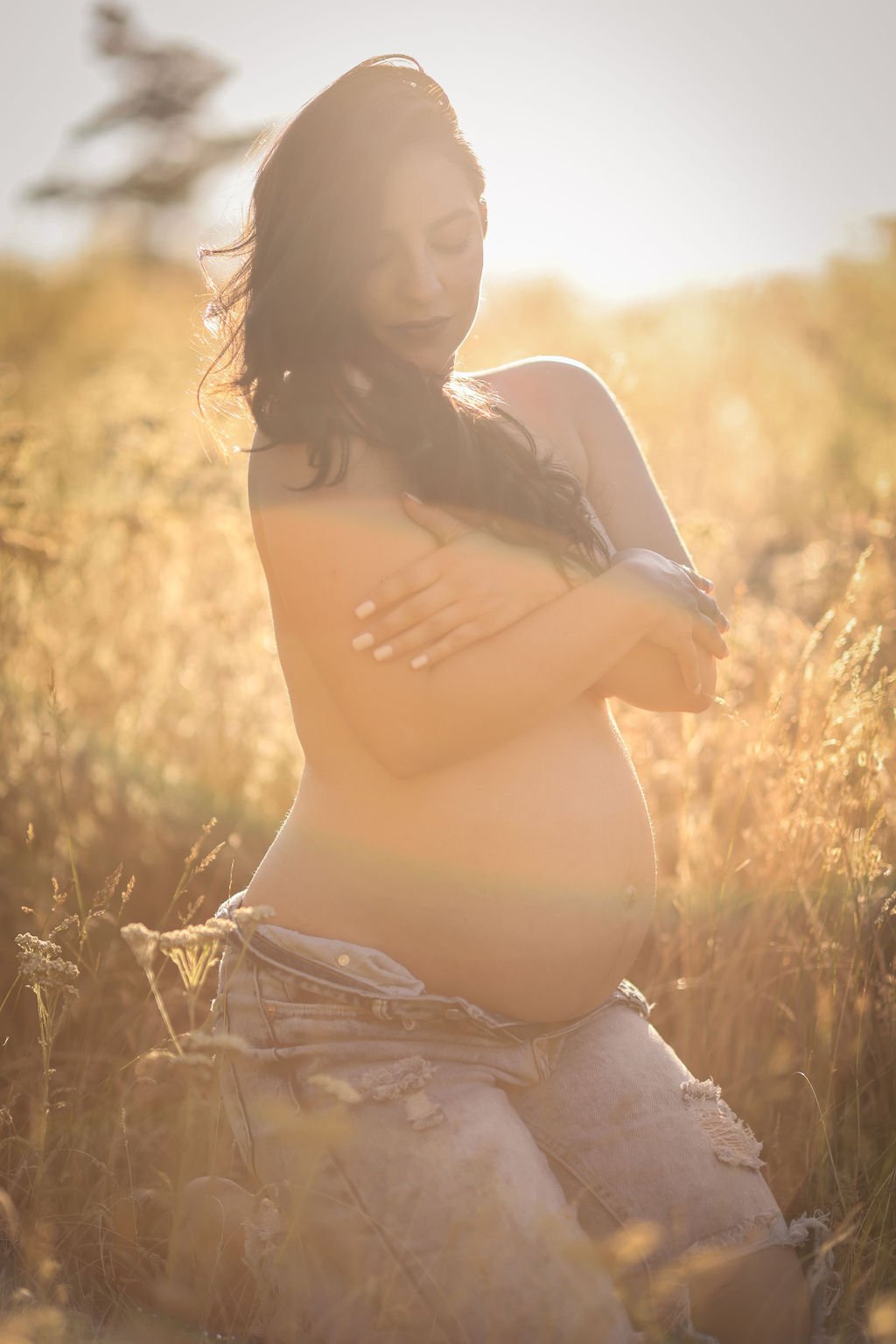 Maternity portrait of woman in jeans topless in Montana field.jpg