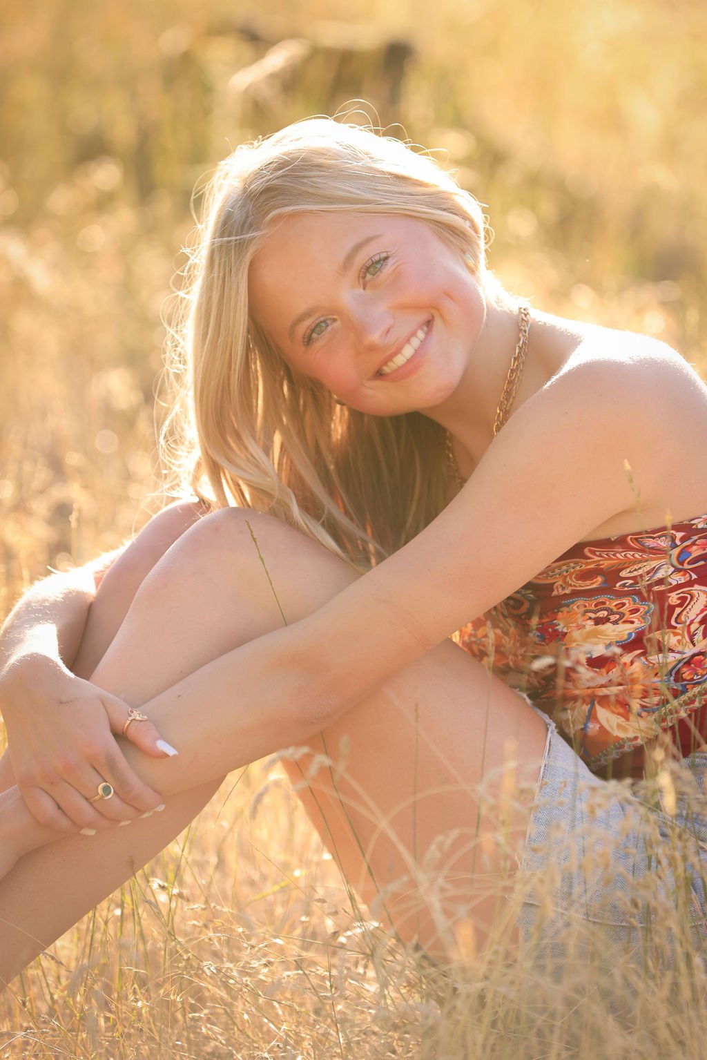 Senior girl smiling in fall field in Montana.jpg