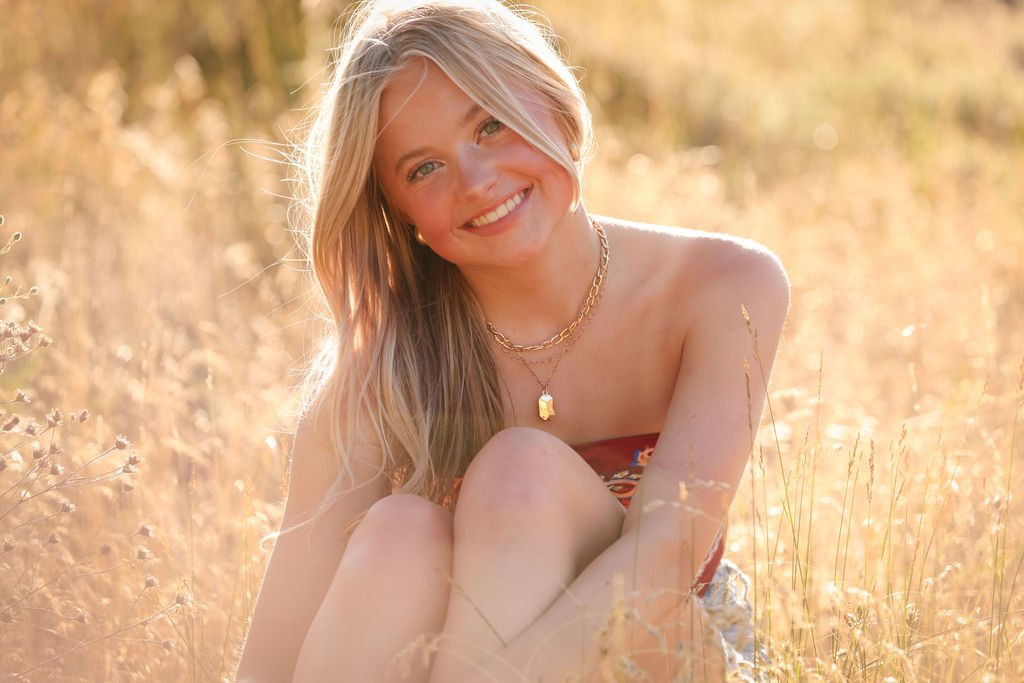 Montana senior girl posing in golden grass field.jpg