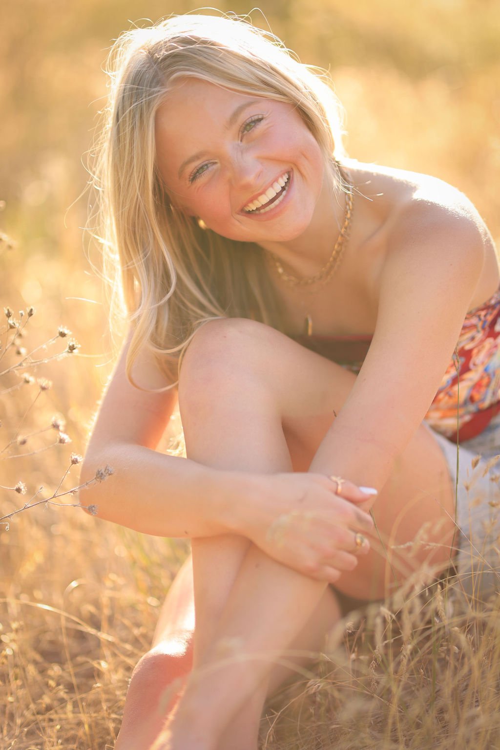 Gorgeous high school senior portrait of girl laughing at golden hour in Montana field.jpg