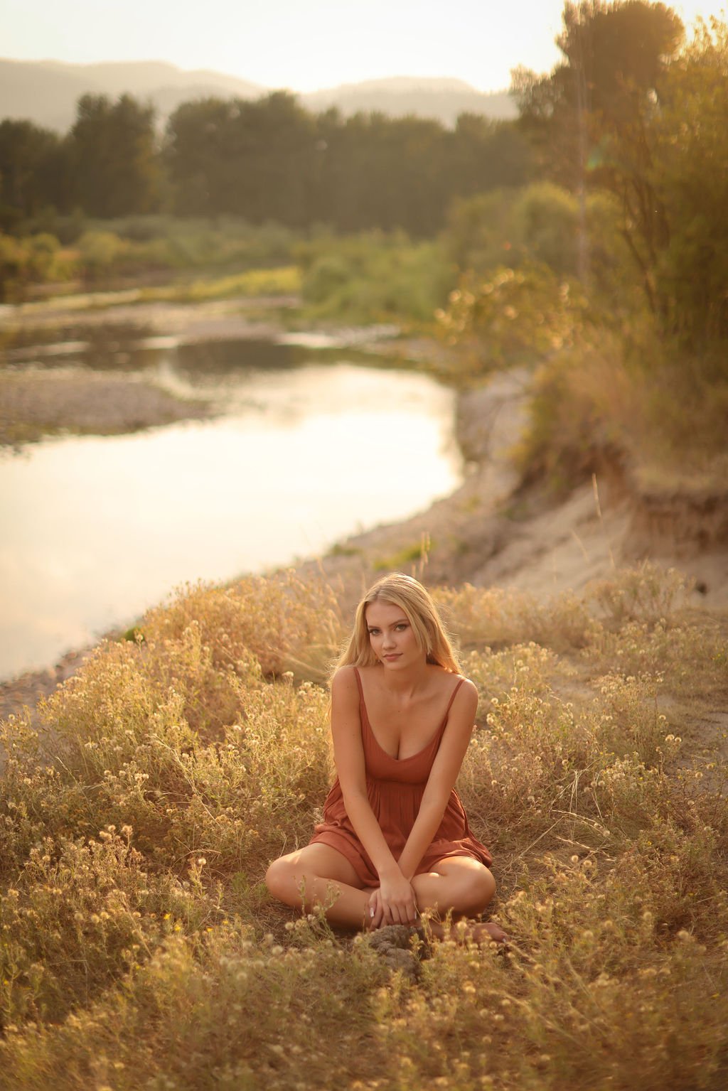 Missoula high school senior portrait smiling in grass field next to river.jpg