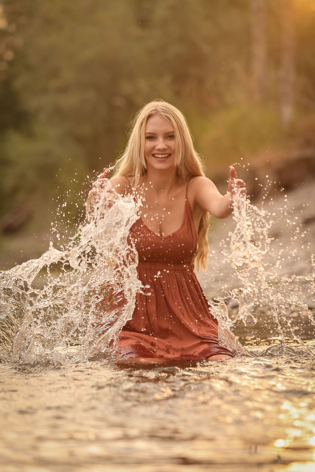Senior portrait of girl in Clarkfork river splashing water.jpg