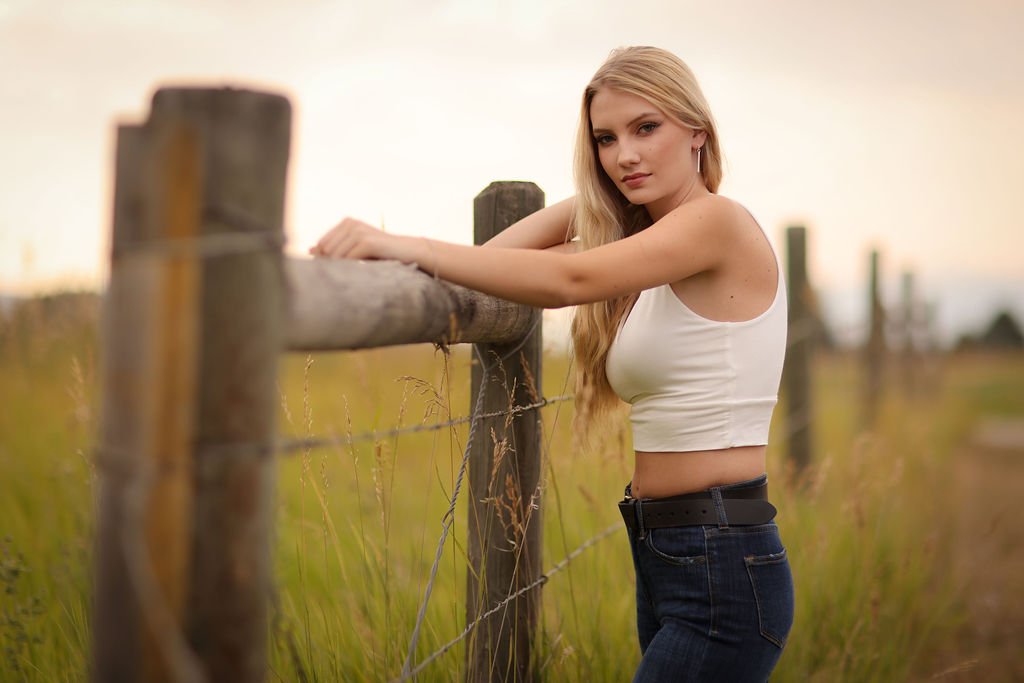 Senior portrait of girl in Montana standing next to wooden fence.jpg