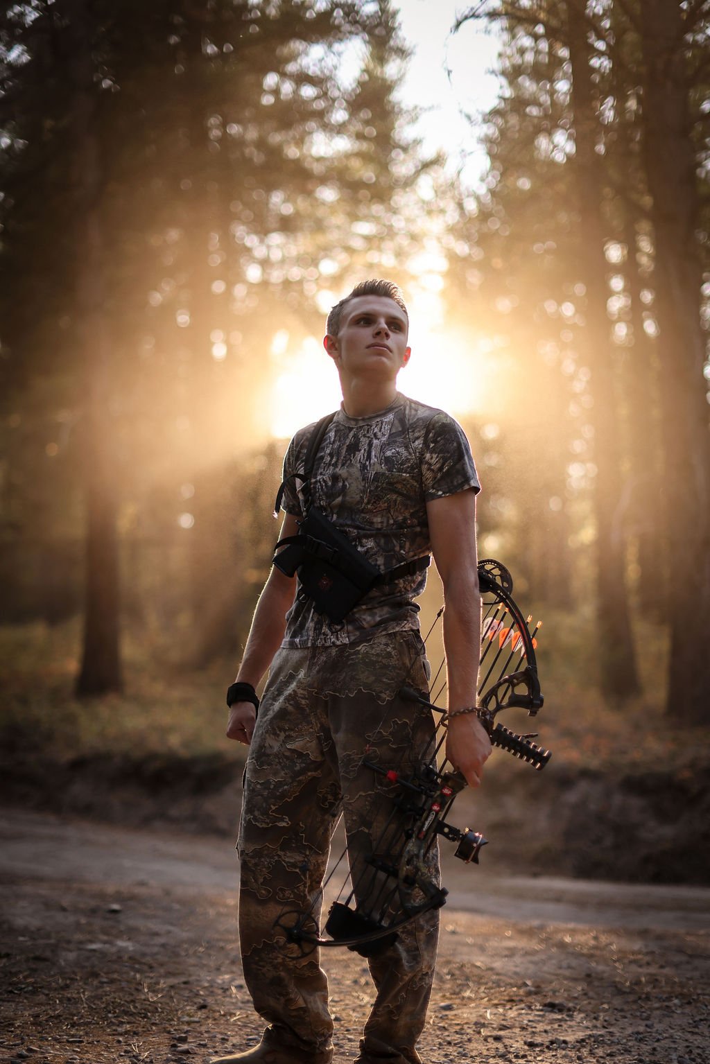 Creative male senior portrait with bow hunting gear.jpg