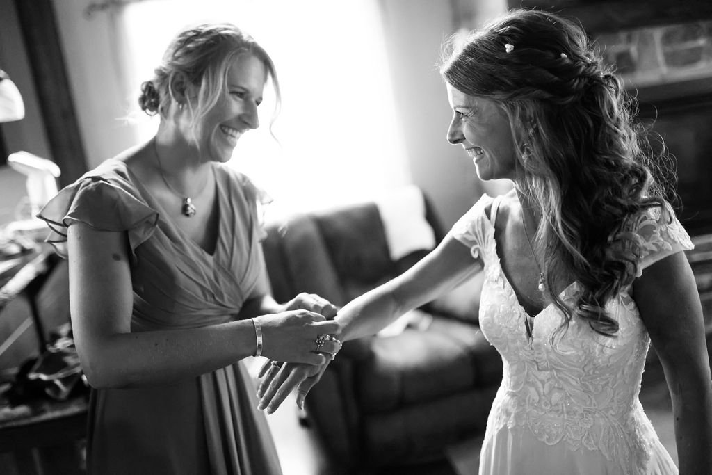 Bridesmaid helping bride get ready during Montana wedding.jpg