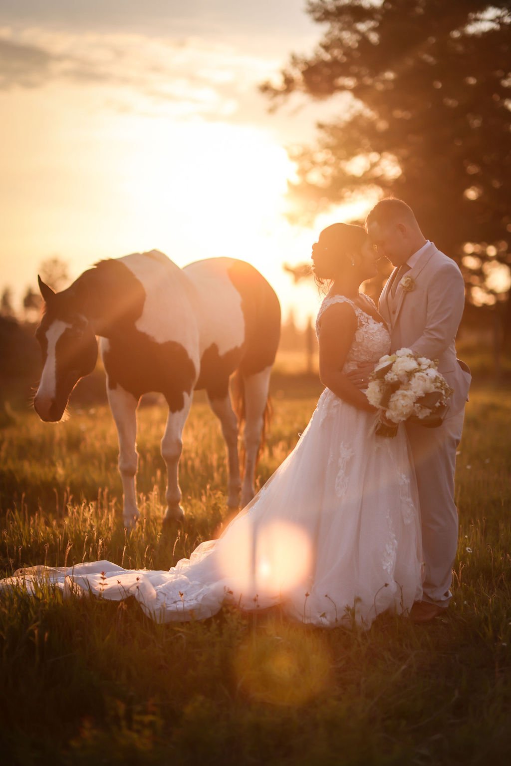 Bride and groom in front of horse at sunset.jpg