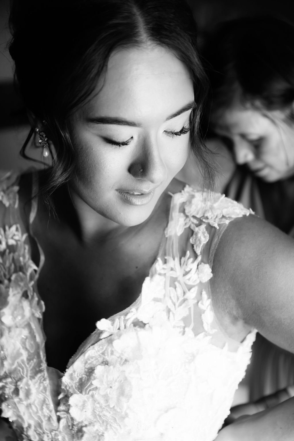 Mother helping bride into wedding gown.jpg