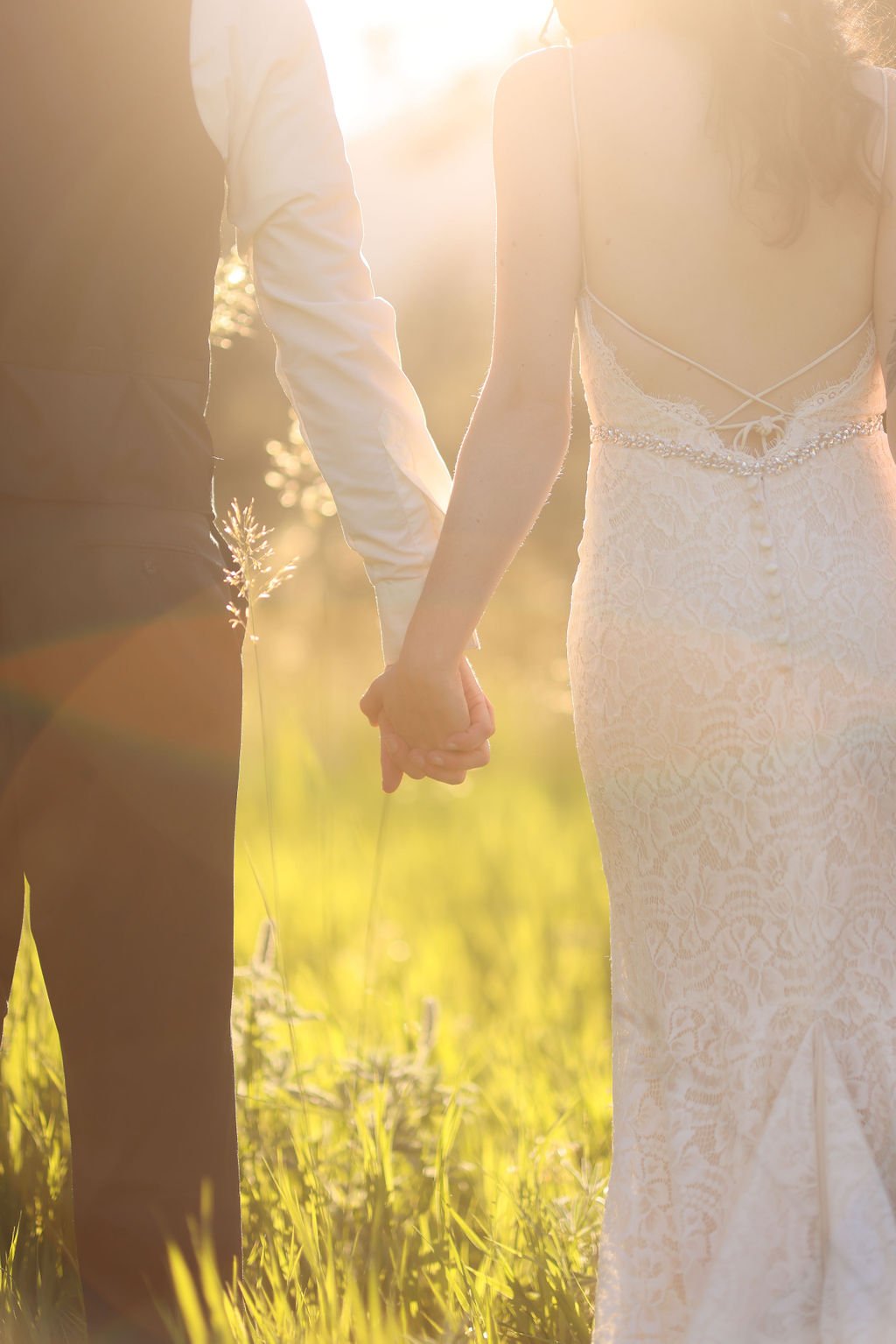 Wedding couple holding hands at sunset at the White Raven Wedding Venue.jpg