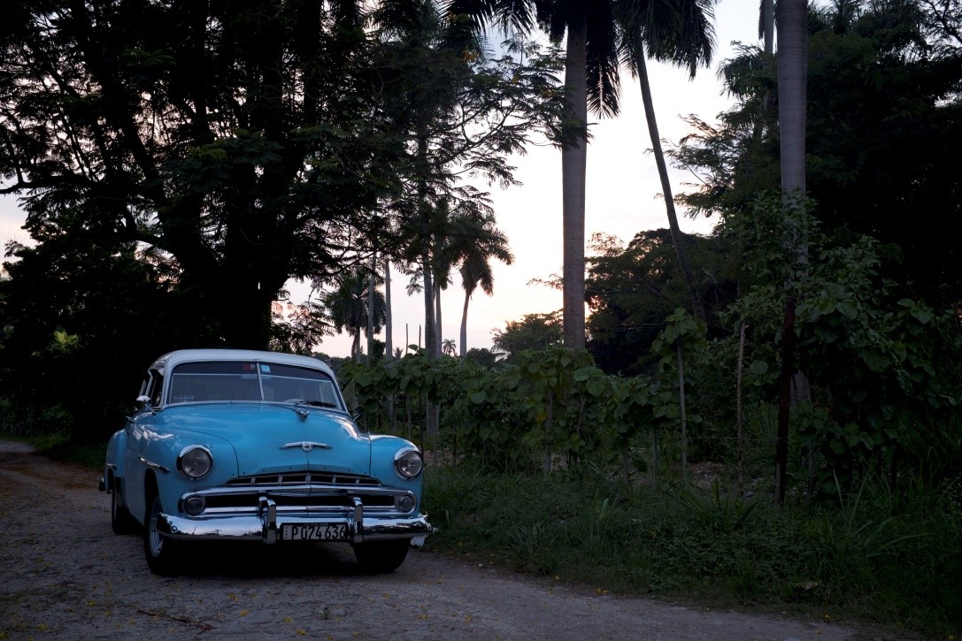 Antique car parked at a country road in El Cotorro, Cuba