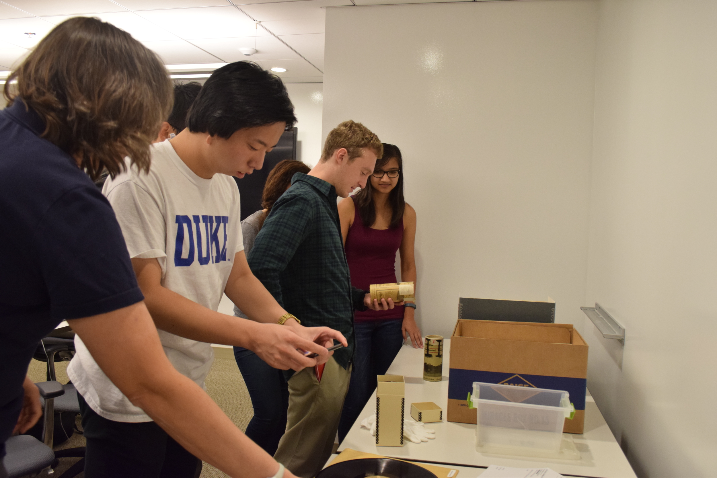 Students examining wax cylinders and glass disks