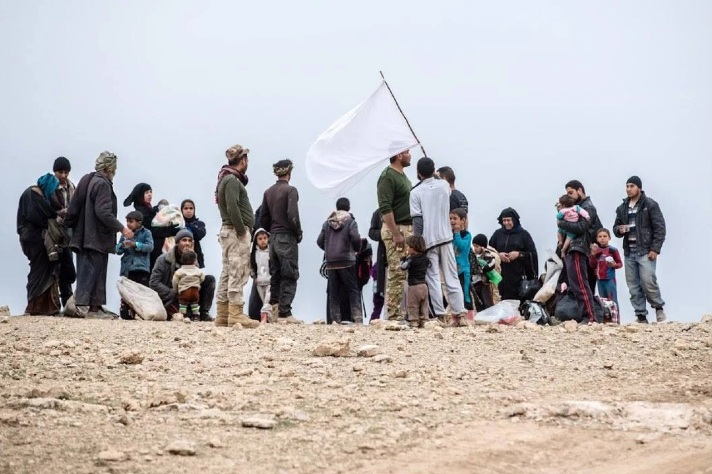 This is an extended family catching their collective breath on the outskirts of Mosul today after escaping ISIS. The white flag they take turns holding high in the air? A plea to not be shot. Fathers holding this flag over their infants and wives, over their nieces and small sons: please do not kill us. Partners, our feet on the ground in Mosul, came across them in this dry and weary land, and gave them a few bottles of water they had in the car, and some food. At this small kindness, grown men broke down and wept and our team felt their bone-cold despair.