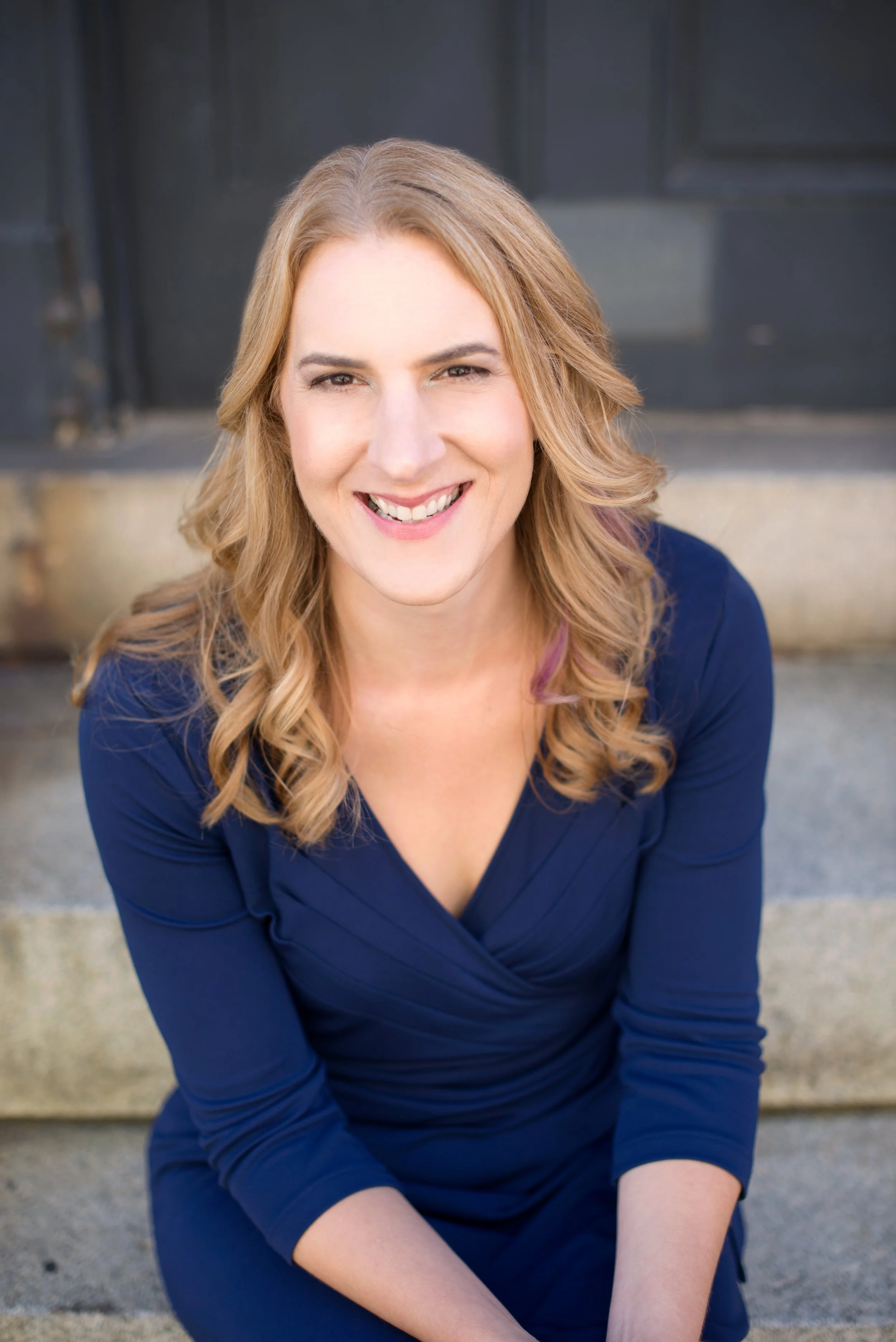 Photo fo Carrie Hane, a blonde, white woman with a navy blue dress on