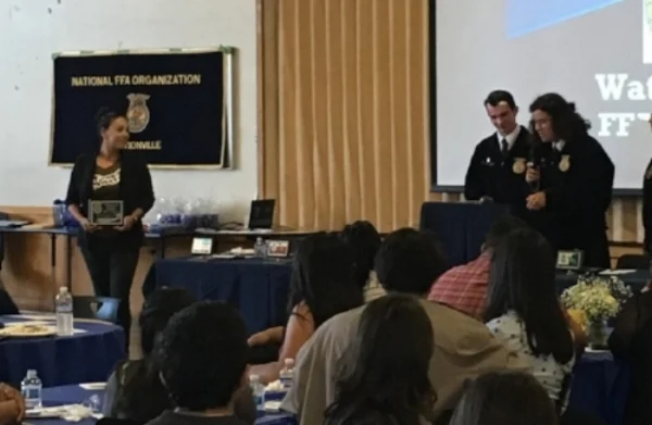 Programs Manager Irene Juarez O'Connell accepting an award on behalf of FoodWhat from the Watsonville Chapter of the Future Farmers of America at their awards banquet at Watsonville High School last month.