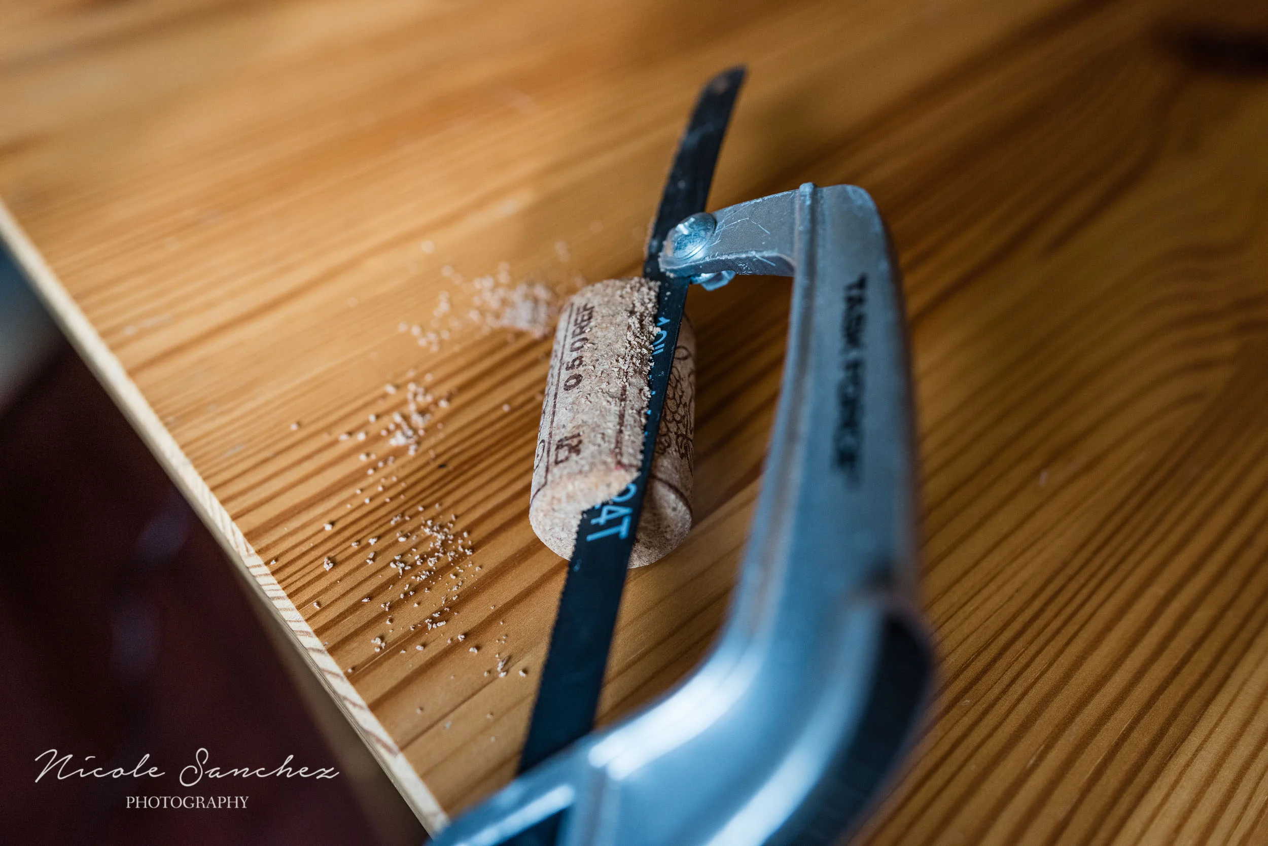Using a hand saw to cut cork by Alexandria, VA Family Photographer Nicole Sanchez