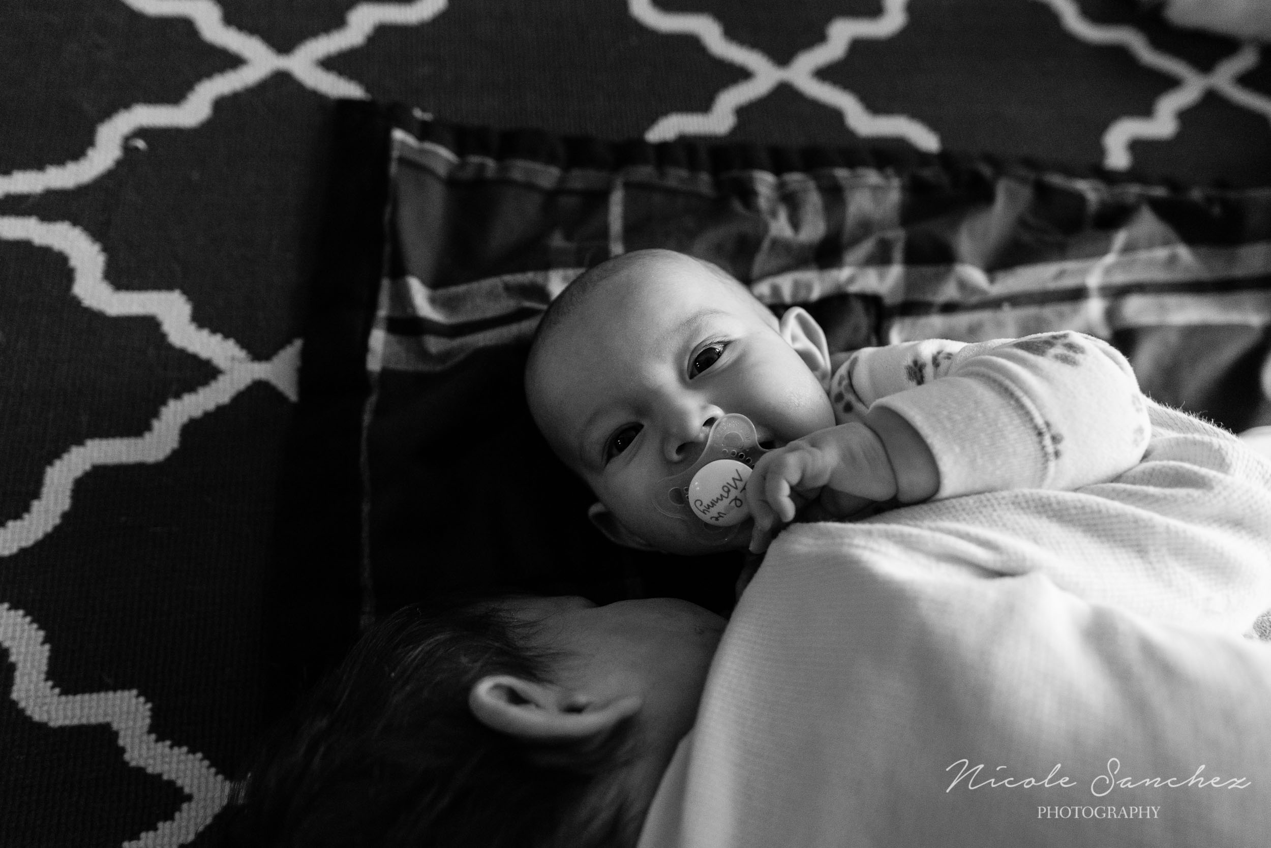 Baby boy smiling with pacifier in mouth by Northern Virginia Lifestyle Photographer Nicole Sanchez