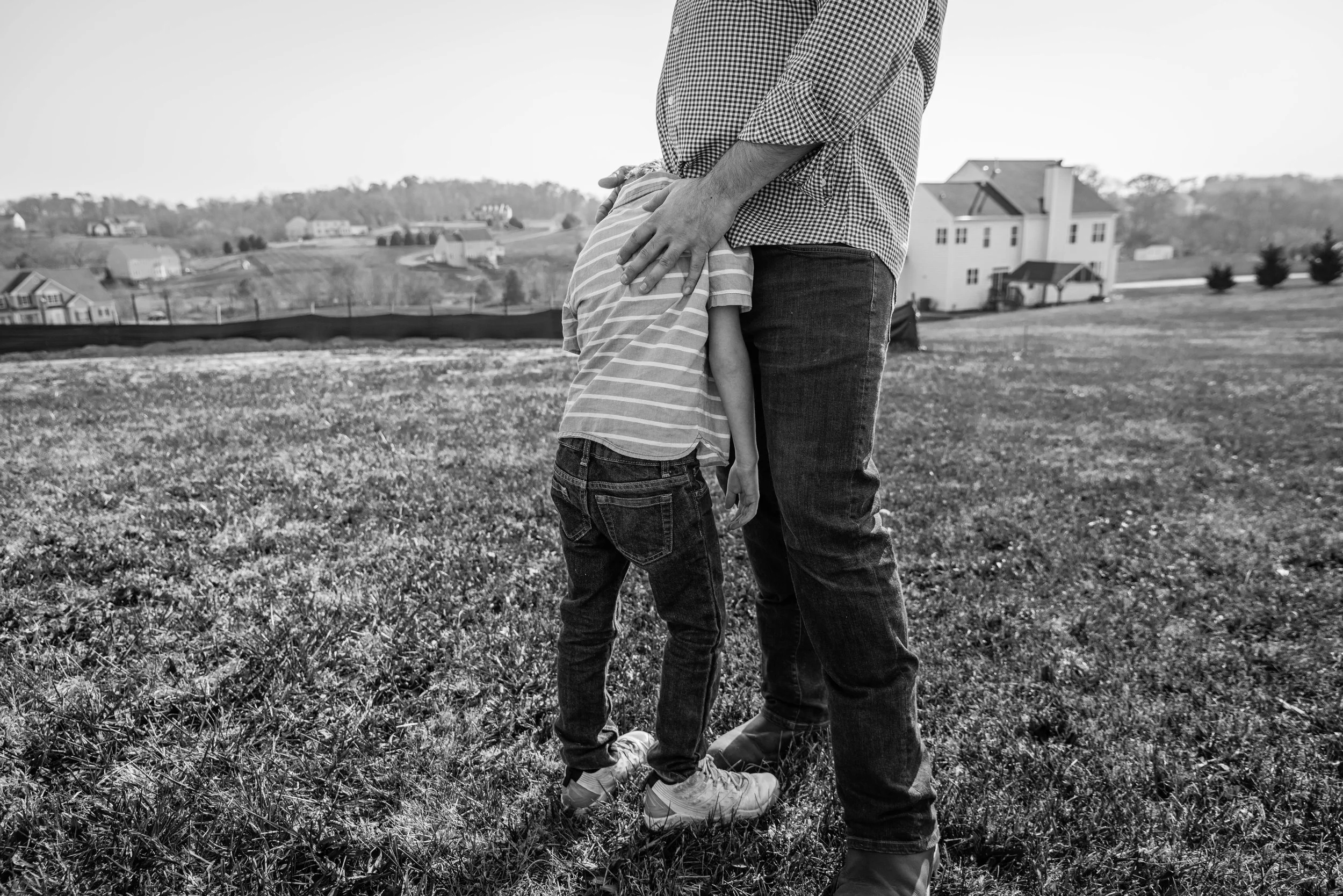 Candid moment of Dad comforting son by Northern Virginia Family Photographer Nicole Sanchez