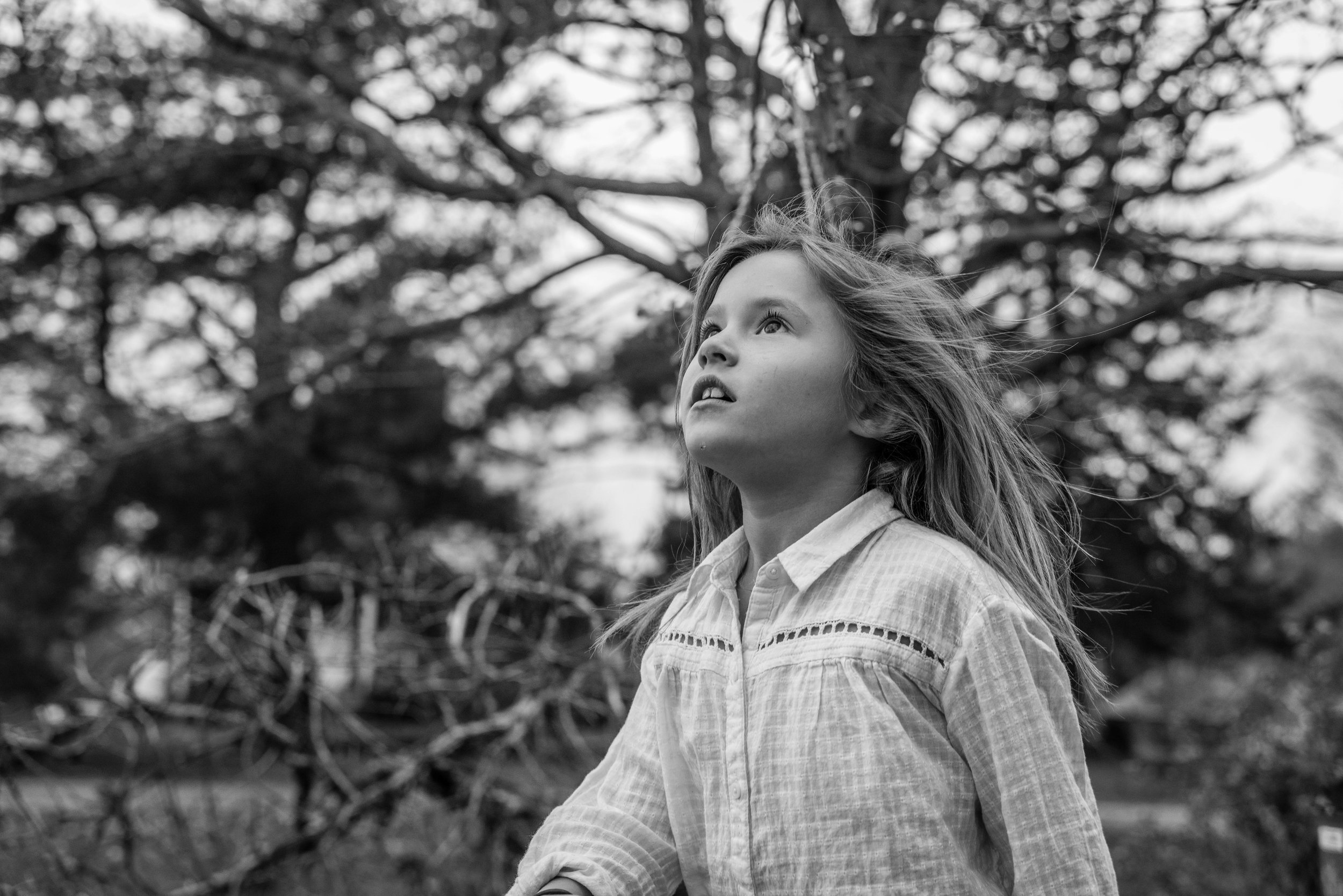 Girl chasing leaves with wind in her hair by Alexandria, VA Lifestyle Photographer