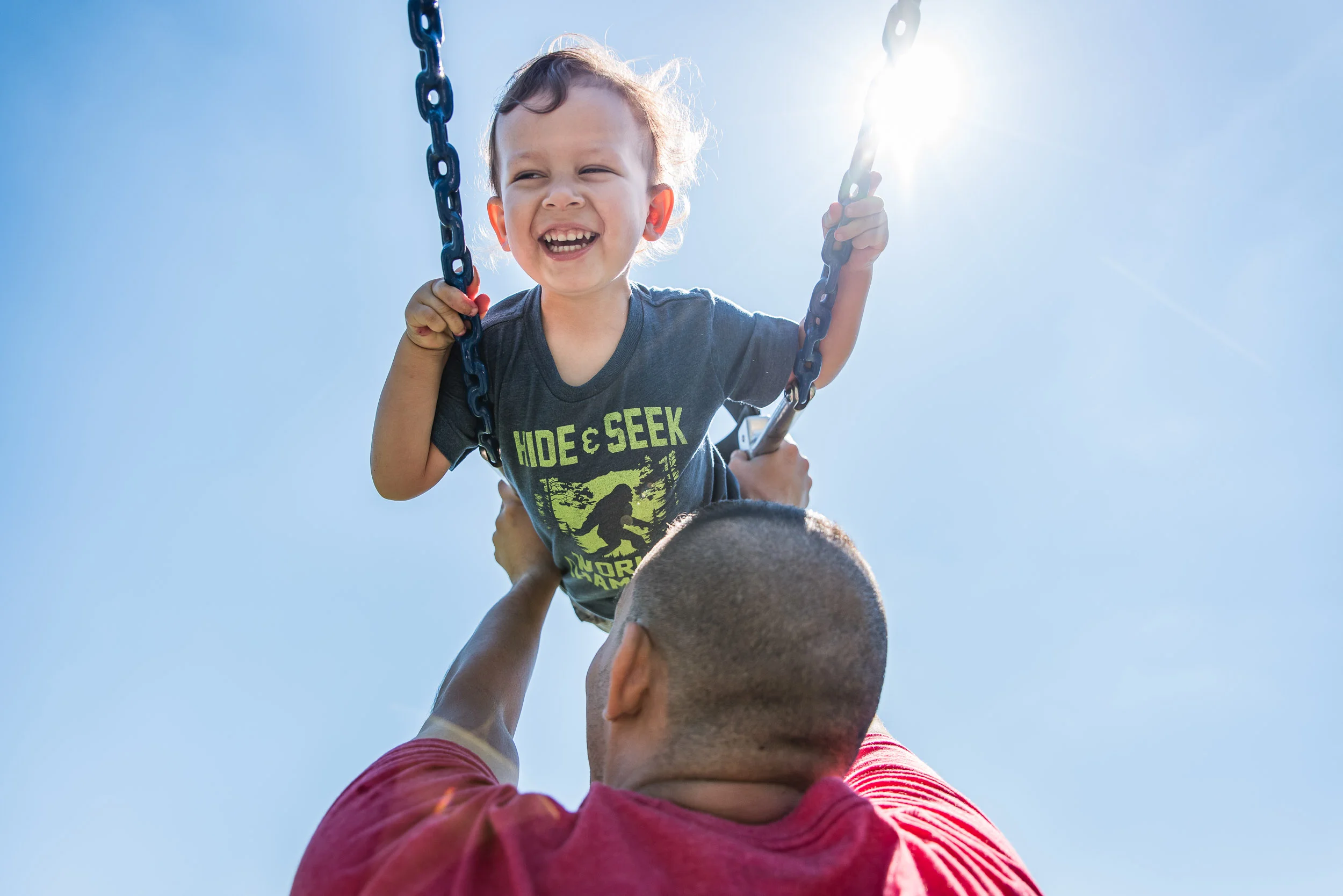 Boy on swings at Jones Point Park in Alexandria, Virginia by Family Photographer Nicole Sanchez