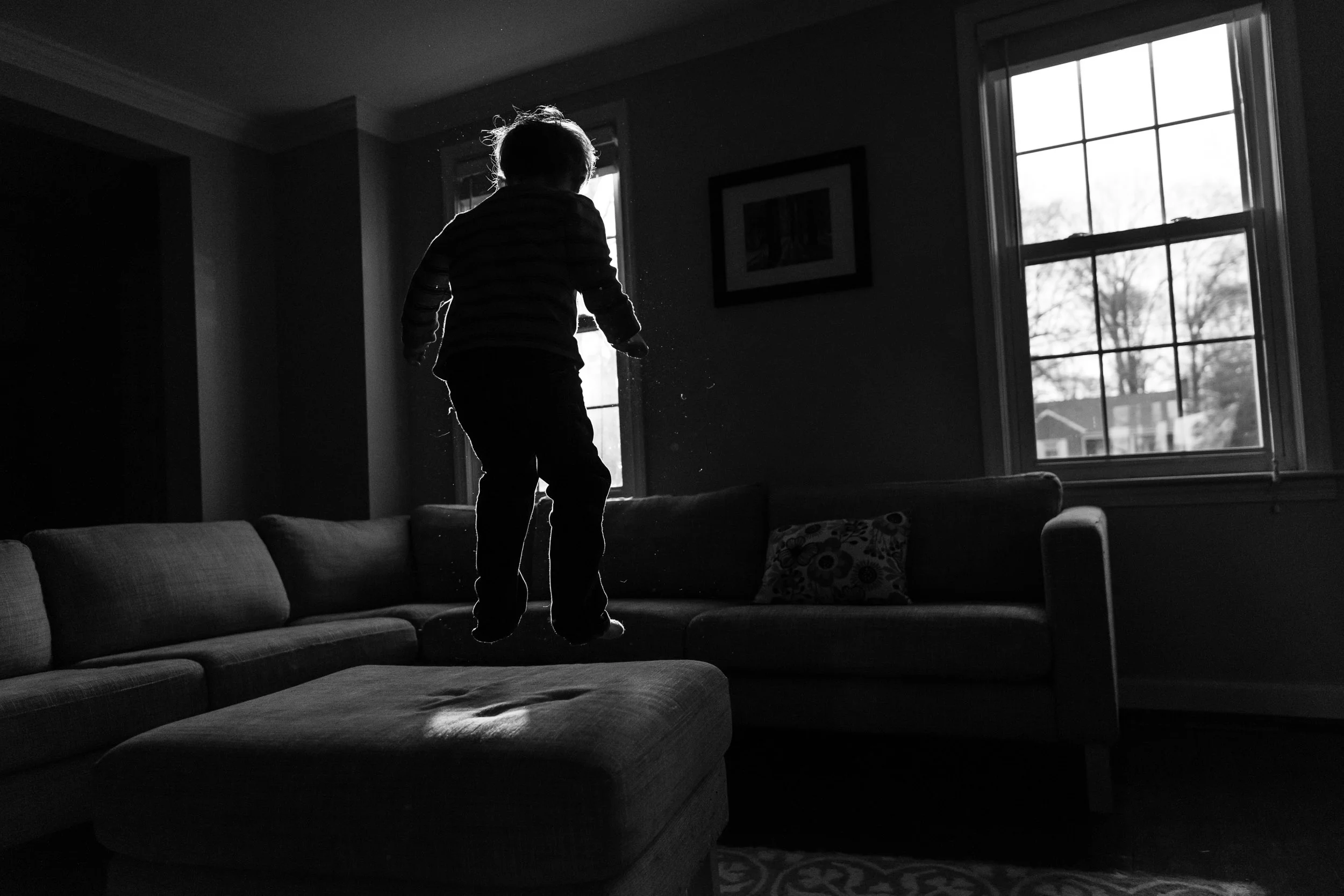 Boy jumping on couch with rim light by Northern Virginia Family Photographer Nicole Sanchez
