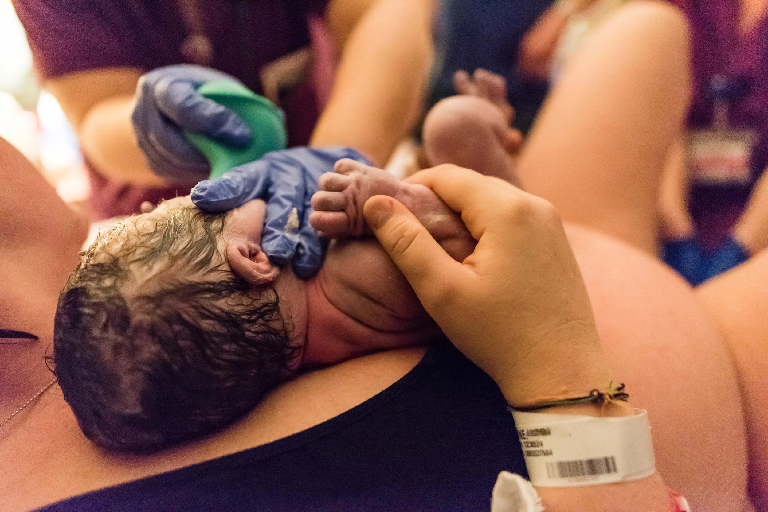 Mother holding newborn baby by Northern Virginia Family Photographer Nicole Sanchez