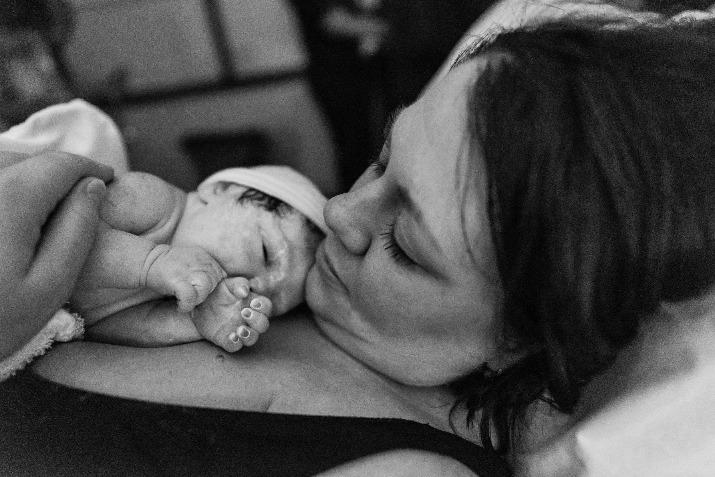 Woman looking at her newborn baby in Northern Virginia hospital by Family Photographer Nicole Sanchez