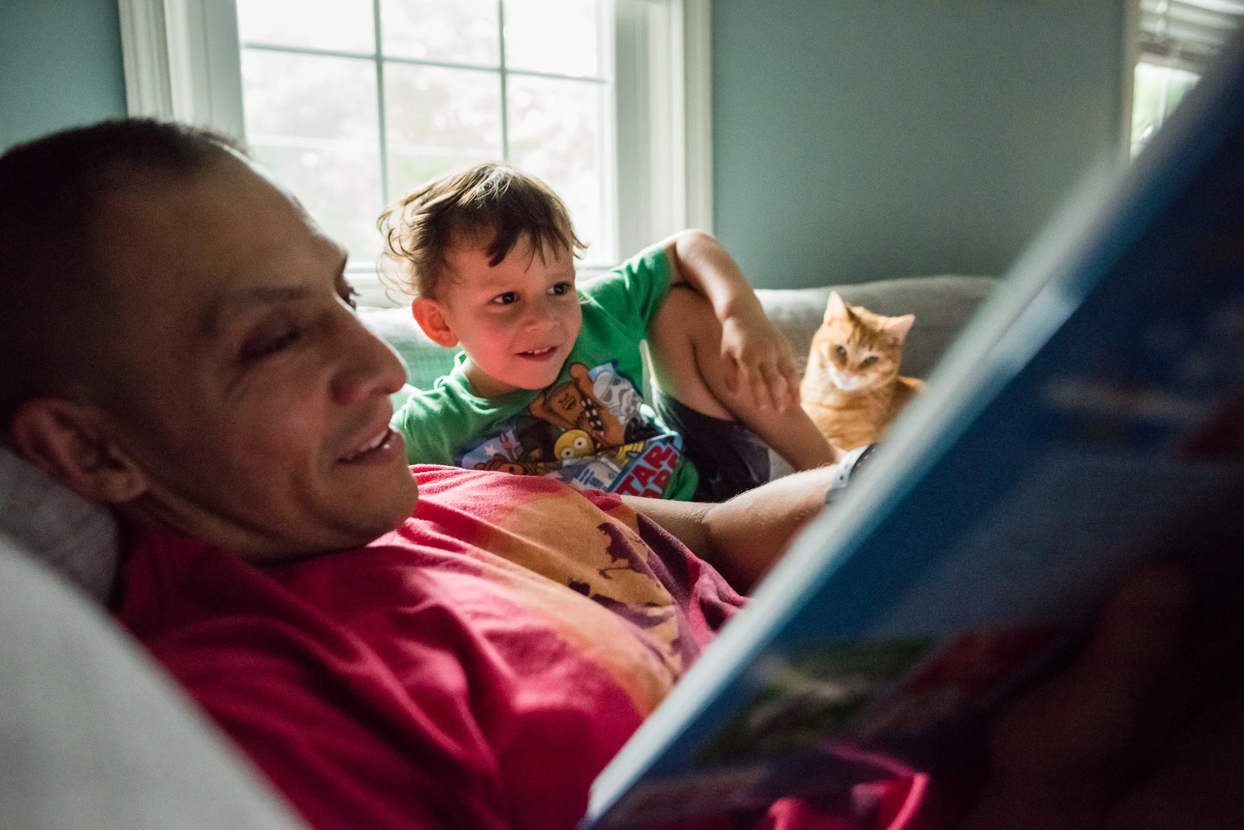 Boy and father reading with cat in Northern Virginia by family photographer Nicole Sanchez