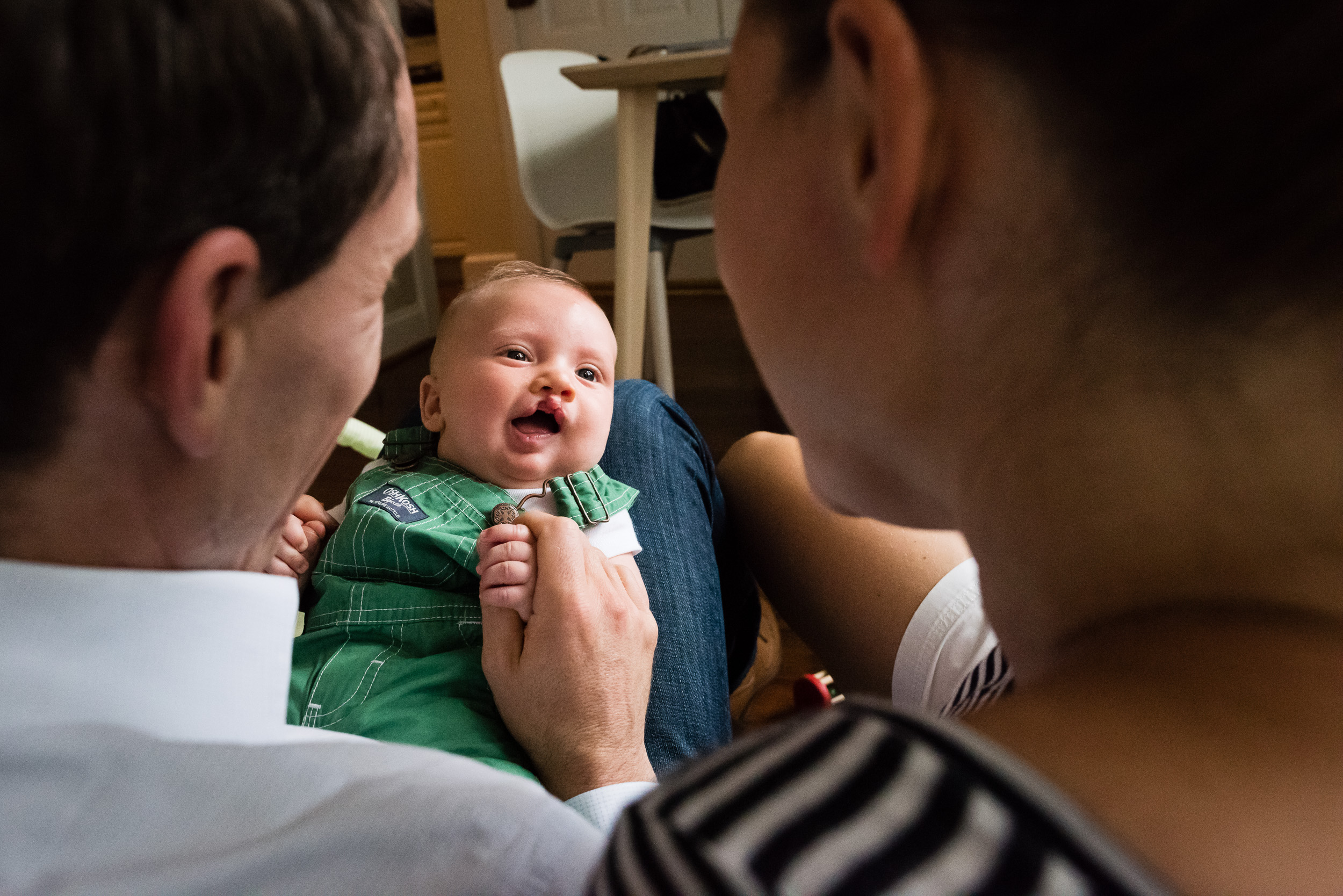 Baby smiling at parents in relaxed in-home photo session by Washington, DC Photographer Nicole Sanchez