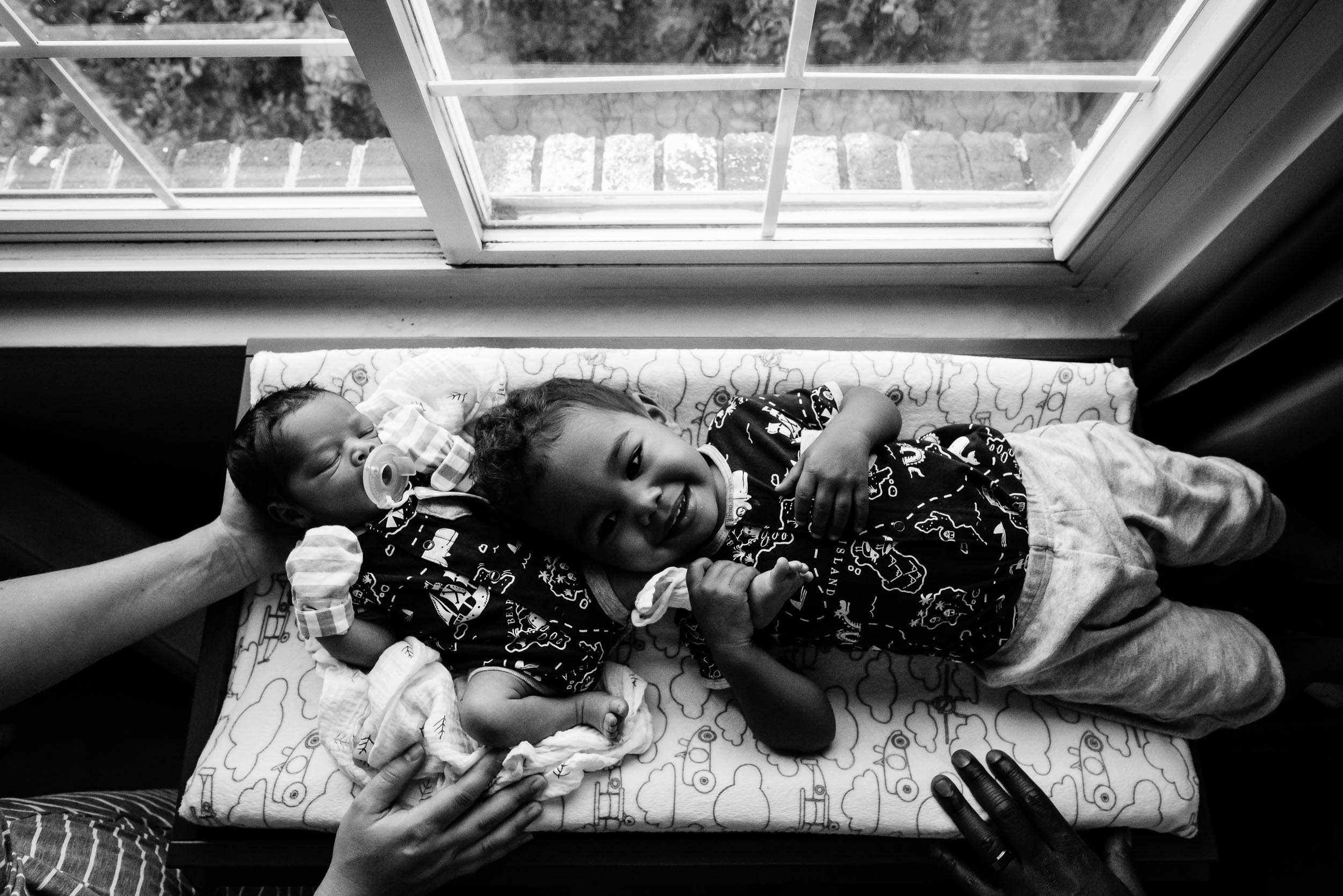 big brother with baby brother in nursery by northern virginia newborn photographer nicole sanchez