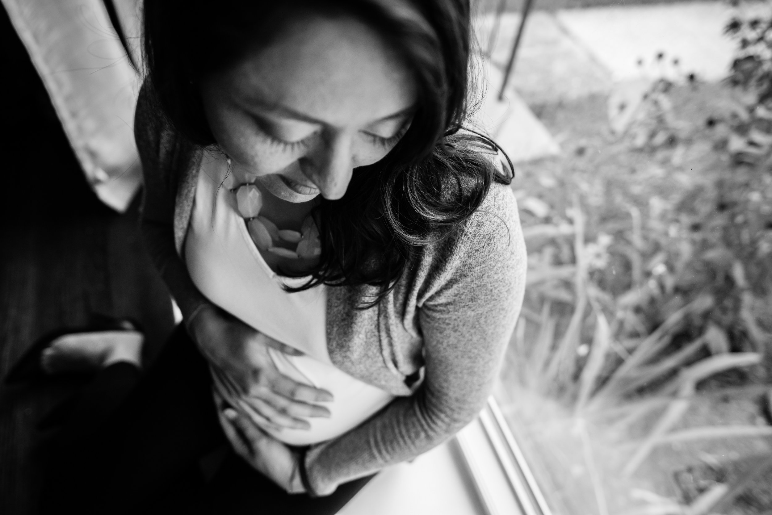 Black and white image of pregnant woman in window in Washington, DC by Family Photographer Nicole Sanchez