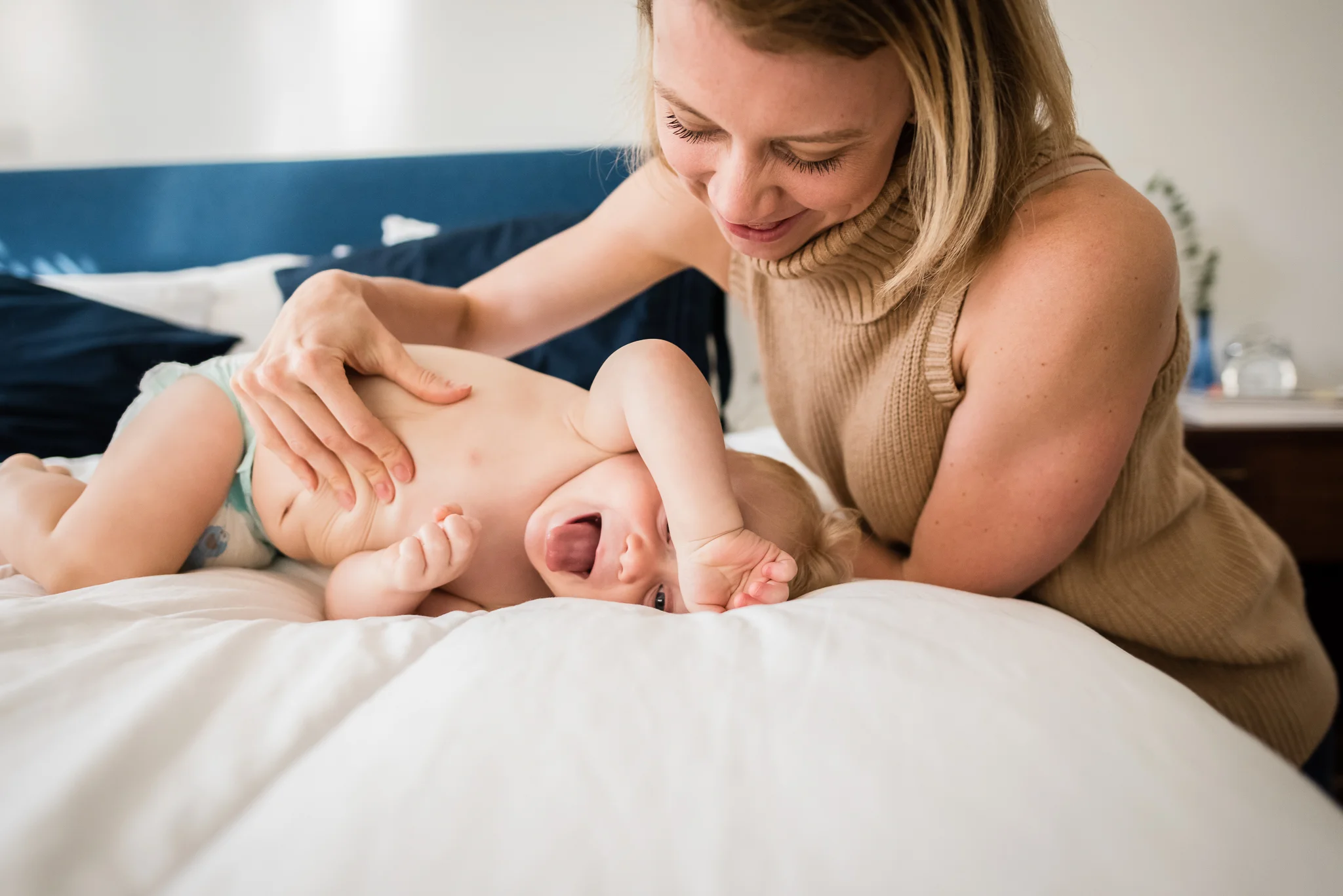 Mom playing on bed with baby in Washington, DC by Family Photographer Nicole Sanchez