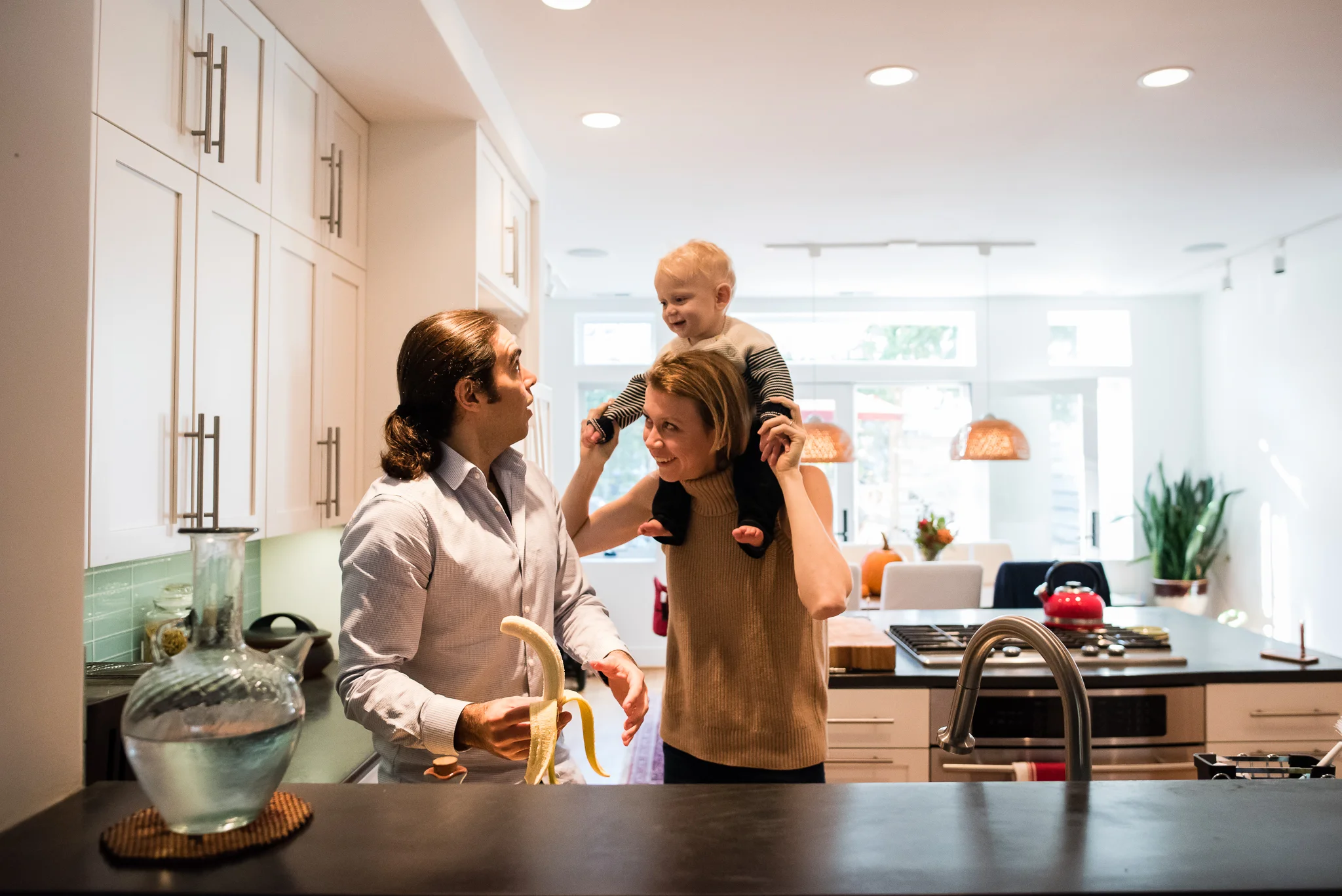 Mom and Dad playing with Baby in Washington, DC kitchen by Family Photographer Nicole Sanchez
