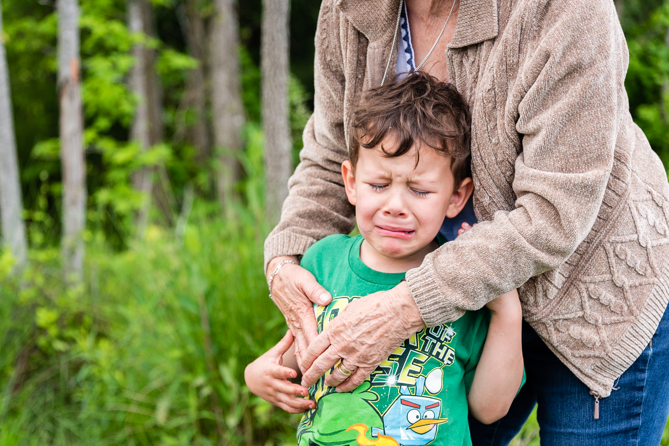 Crying boy being comforted by grandmother by Northern Virginia Family Photographer Nicole Sanchez