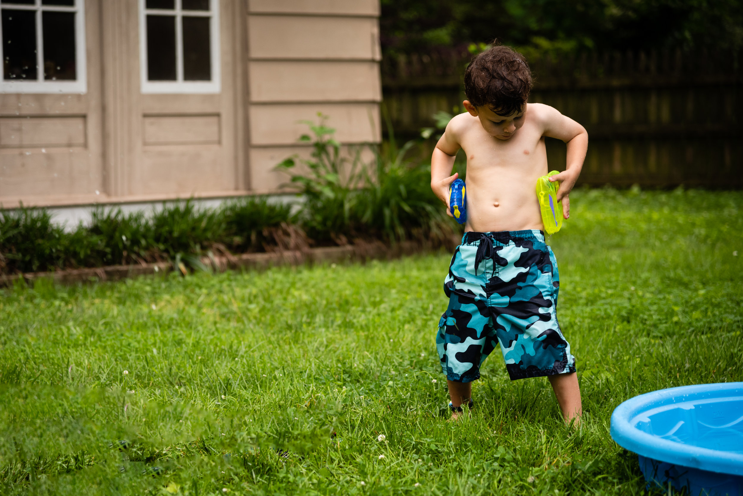 Boy pretending to holster water guns by Northern Virginia Family Photographer Nicole Sanchez