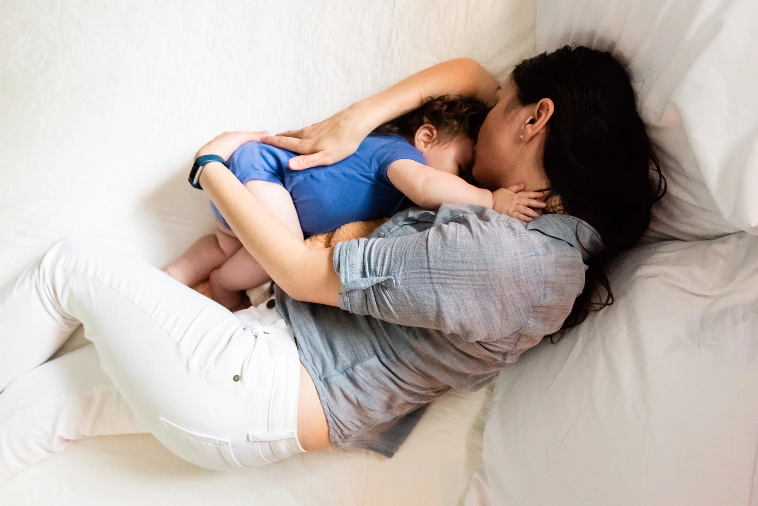 Mother and son snuggling in bed before nap time at home in Alexandria, VA